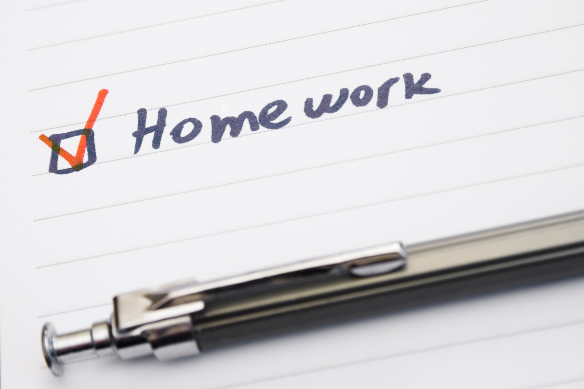 A notebook page with the word "Homework" written next to a checked box, symbolizing relationship homework or a completed couples exercise.
