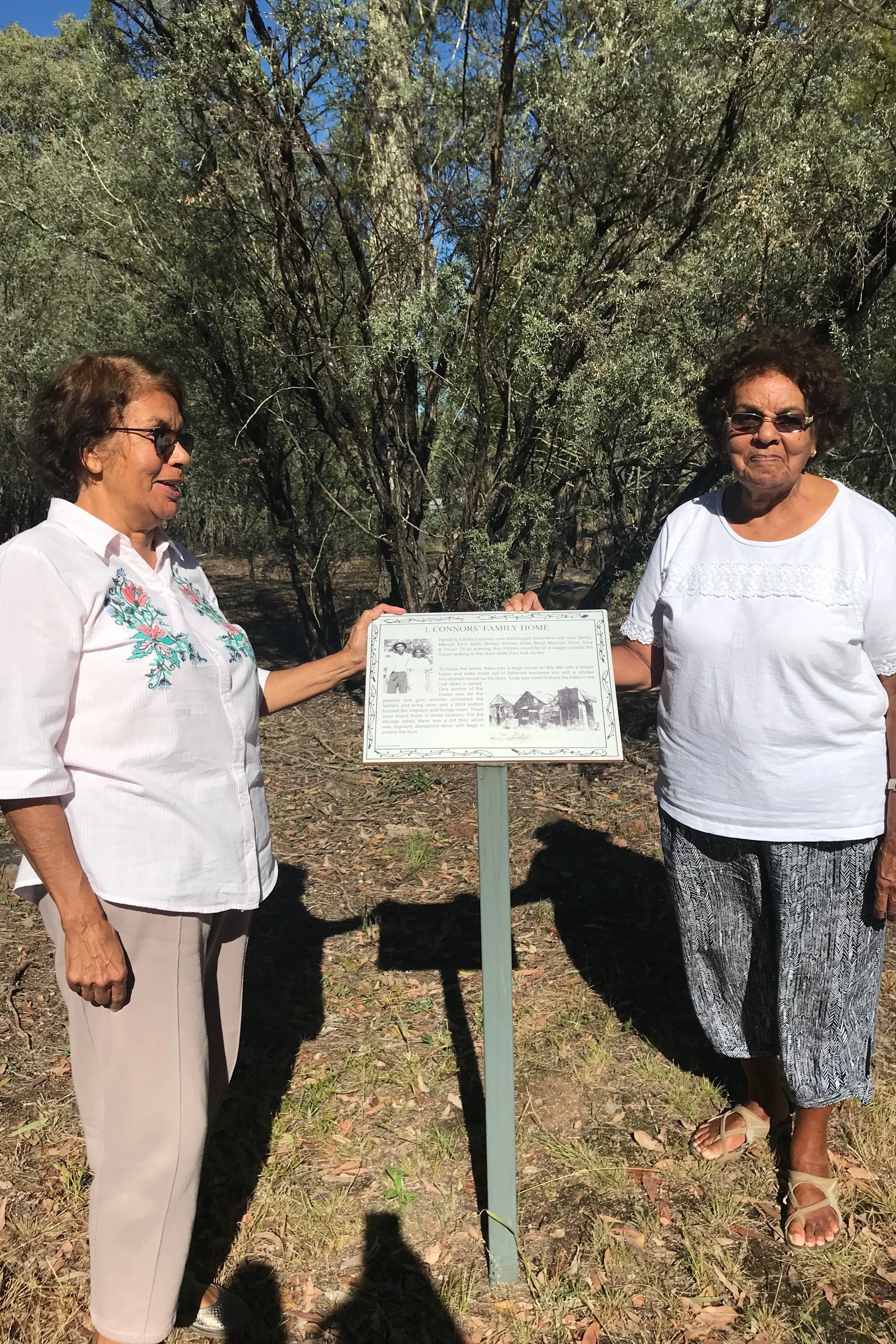 Beryl Hepi and Hilda Dunan at the former Goonoowigall camp and standing next to the site of their childhood house