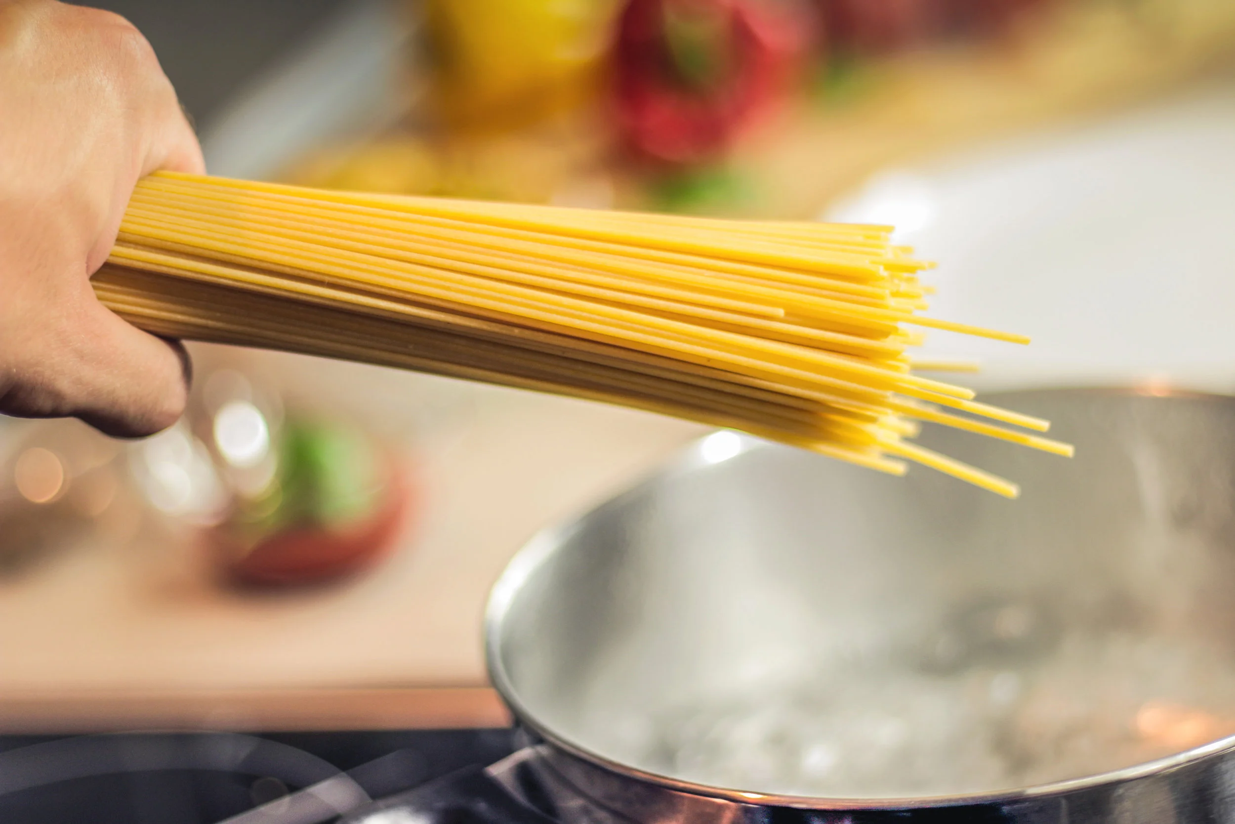 Canva - Person Holding Raw Pastas Aiming at Boiling Water in Pot.jpg