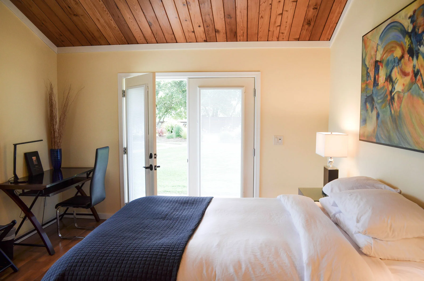 a well lit room with queen bed and desk at Indian Creek Inn just outside of Philo in Anderson Valley, California