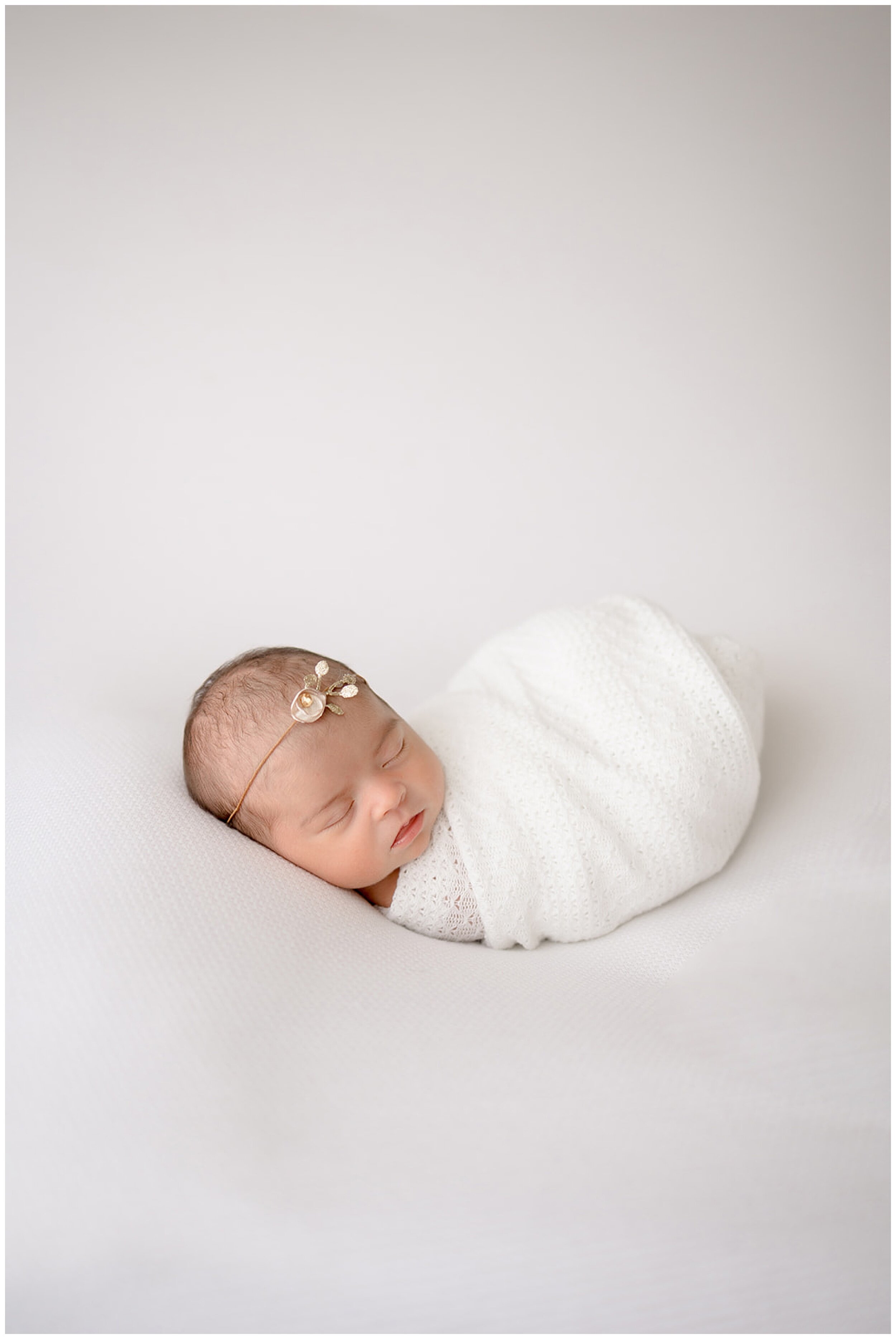 newborn swaddled in white blanket