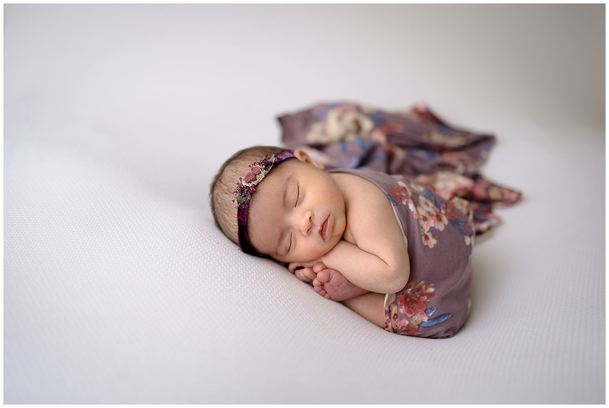 newborn wearing purple