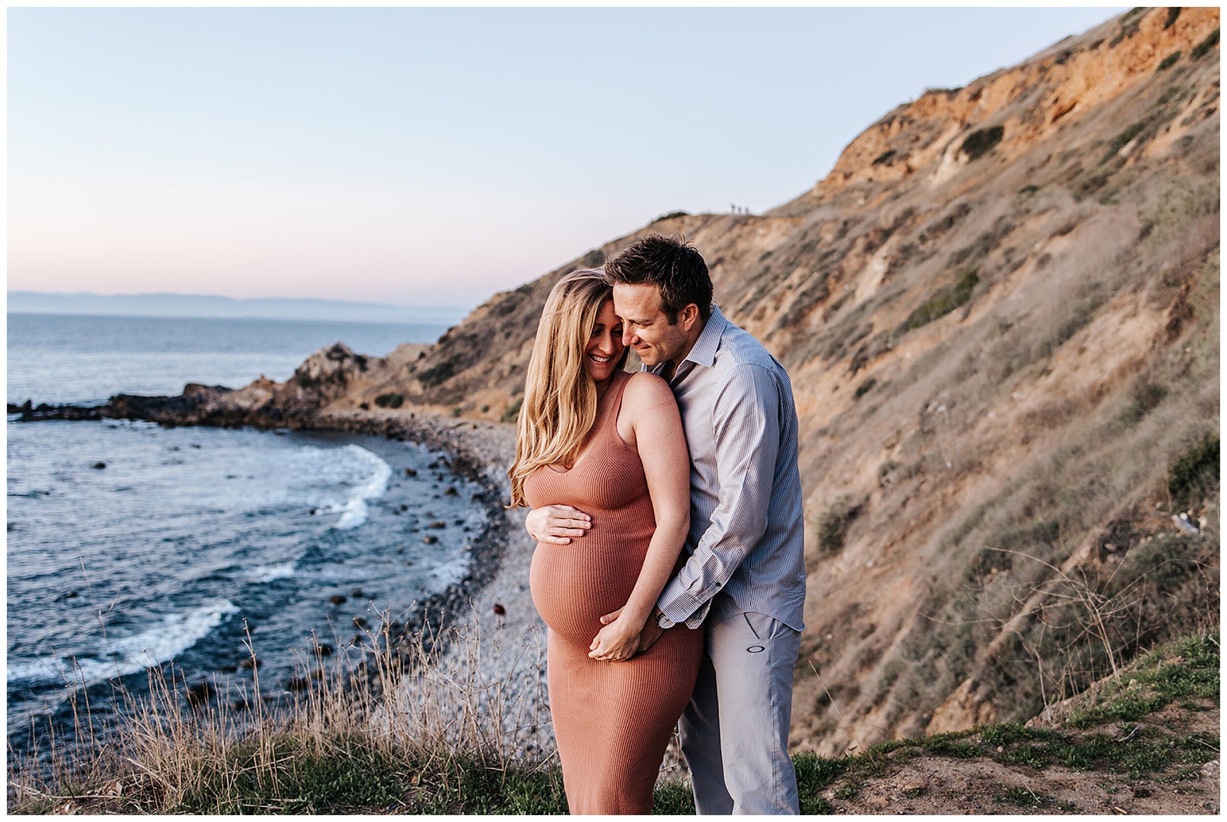 pregnant couple hugging on beach