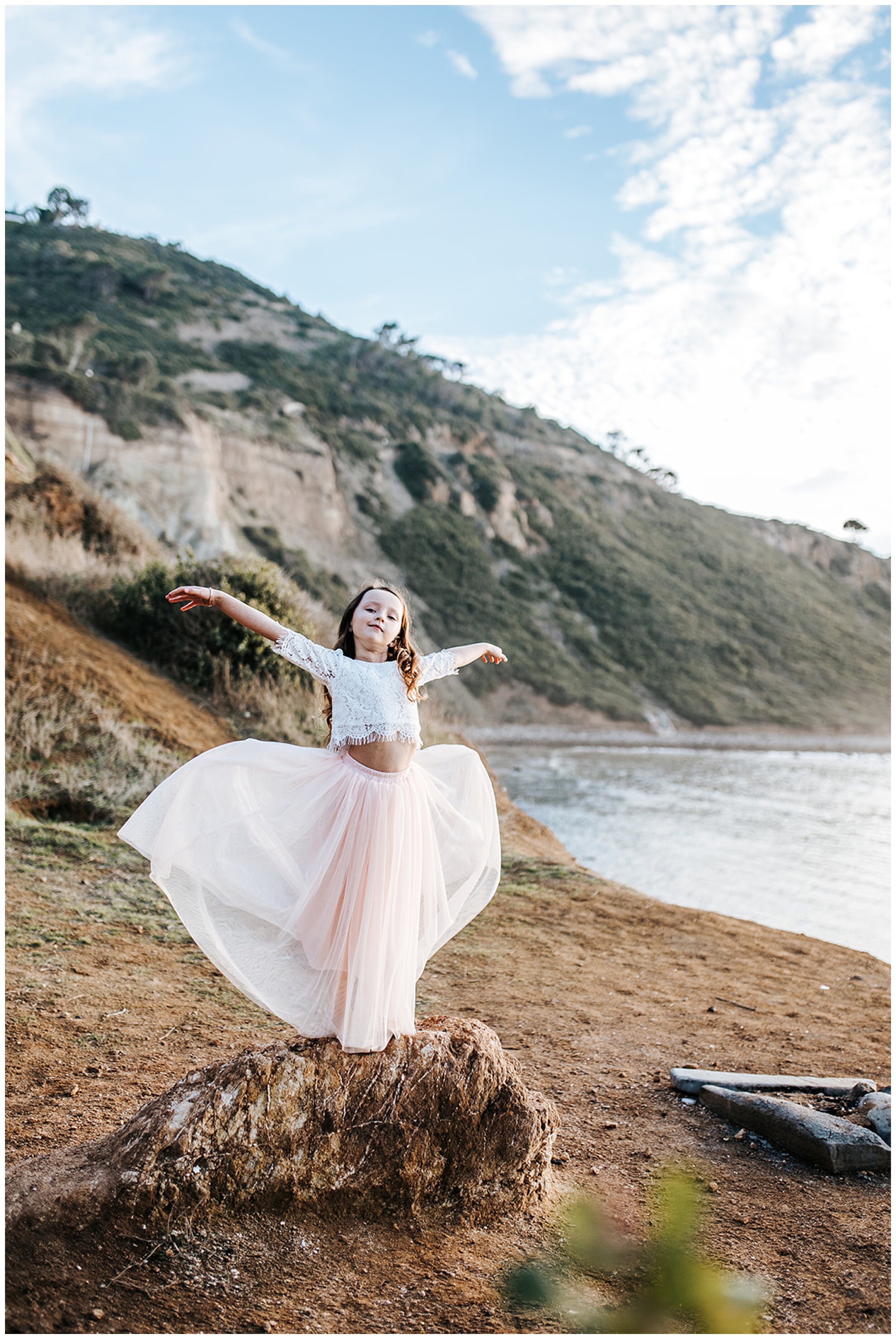 young girl dancing on beach in tutu