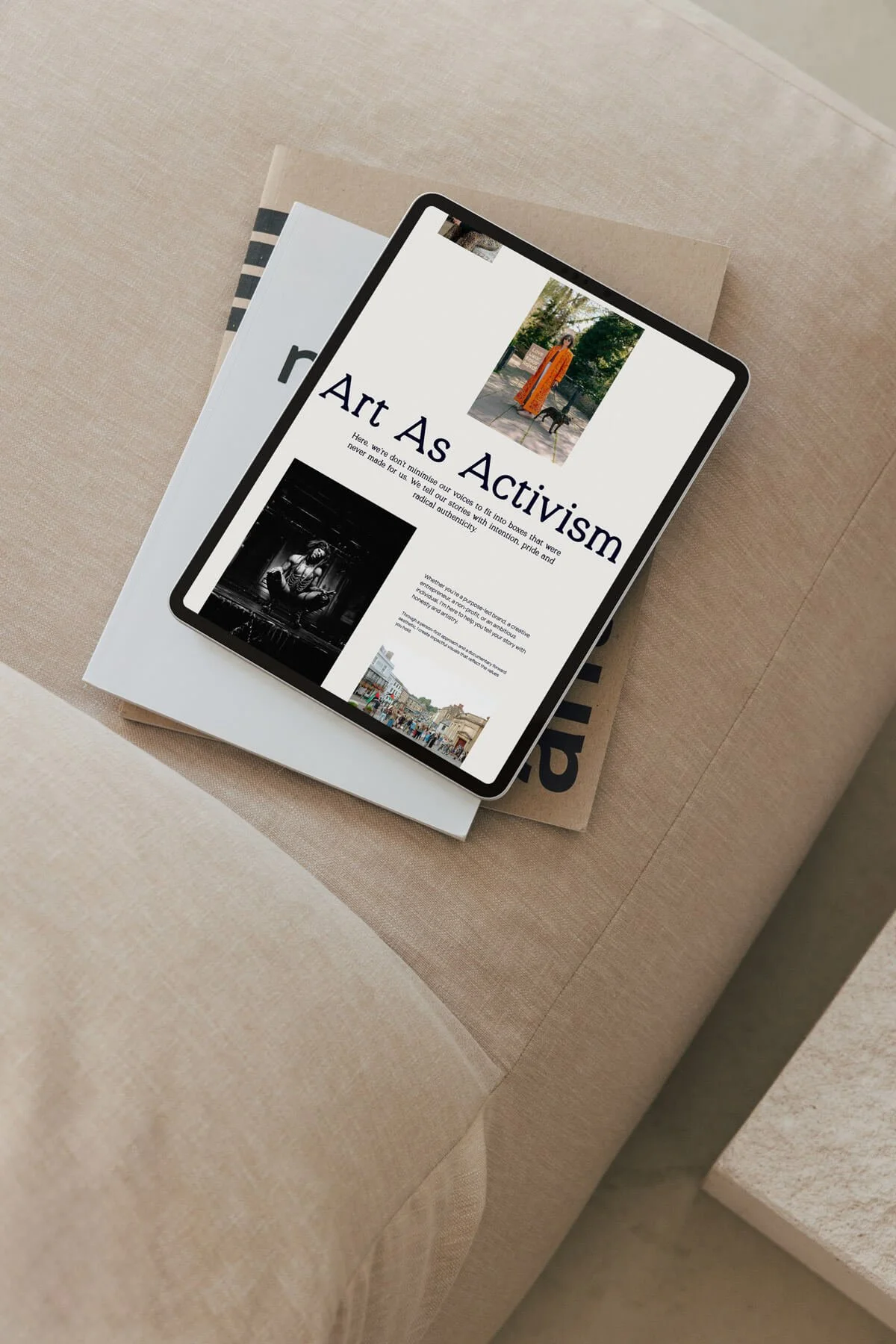 a black ipad stacked on top of notebooks, showing a website homepage for a brand photographer