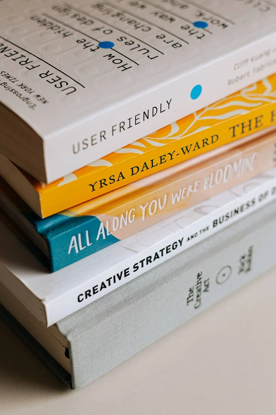 A stack of five books featuring titles about business, creativity, and strategy.