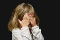 Child girl covering face