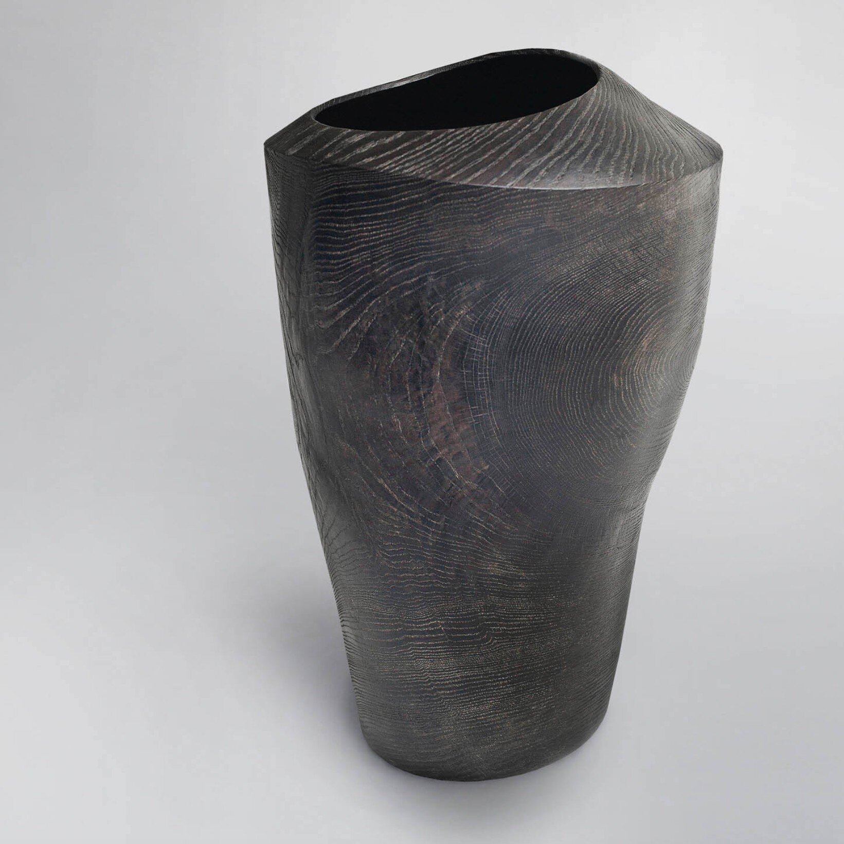 SPRING HOUSE. This stunning vessel is handturned on different axes in an elaborate process following the wood's natural features. Made from local oak and stained black, it makes a sculptural statement in and of itself or as a vase filled with seasona