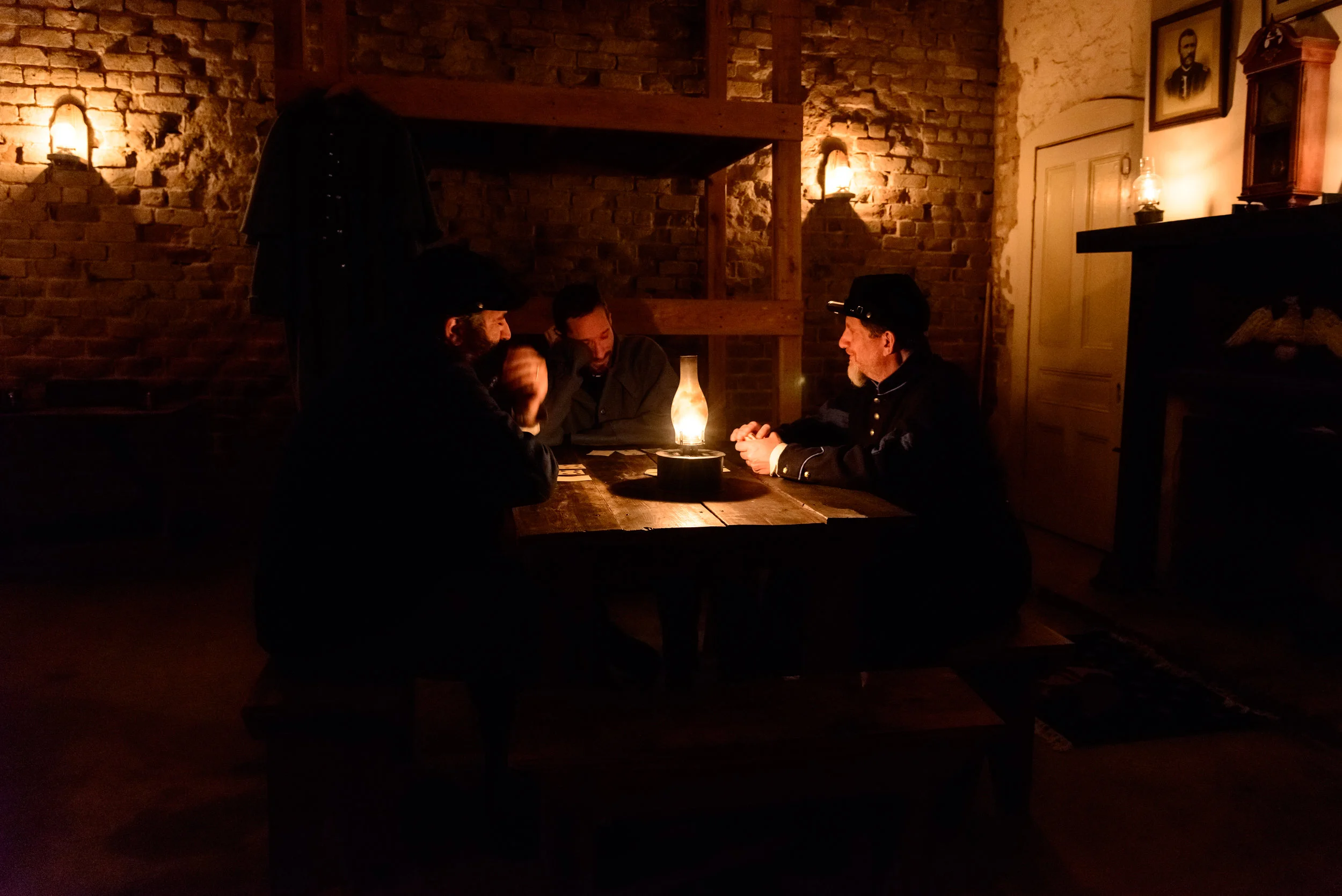Volunteer re-enactors staying in the fort over night play cards to pass the time.