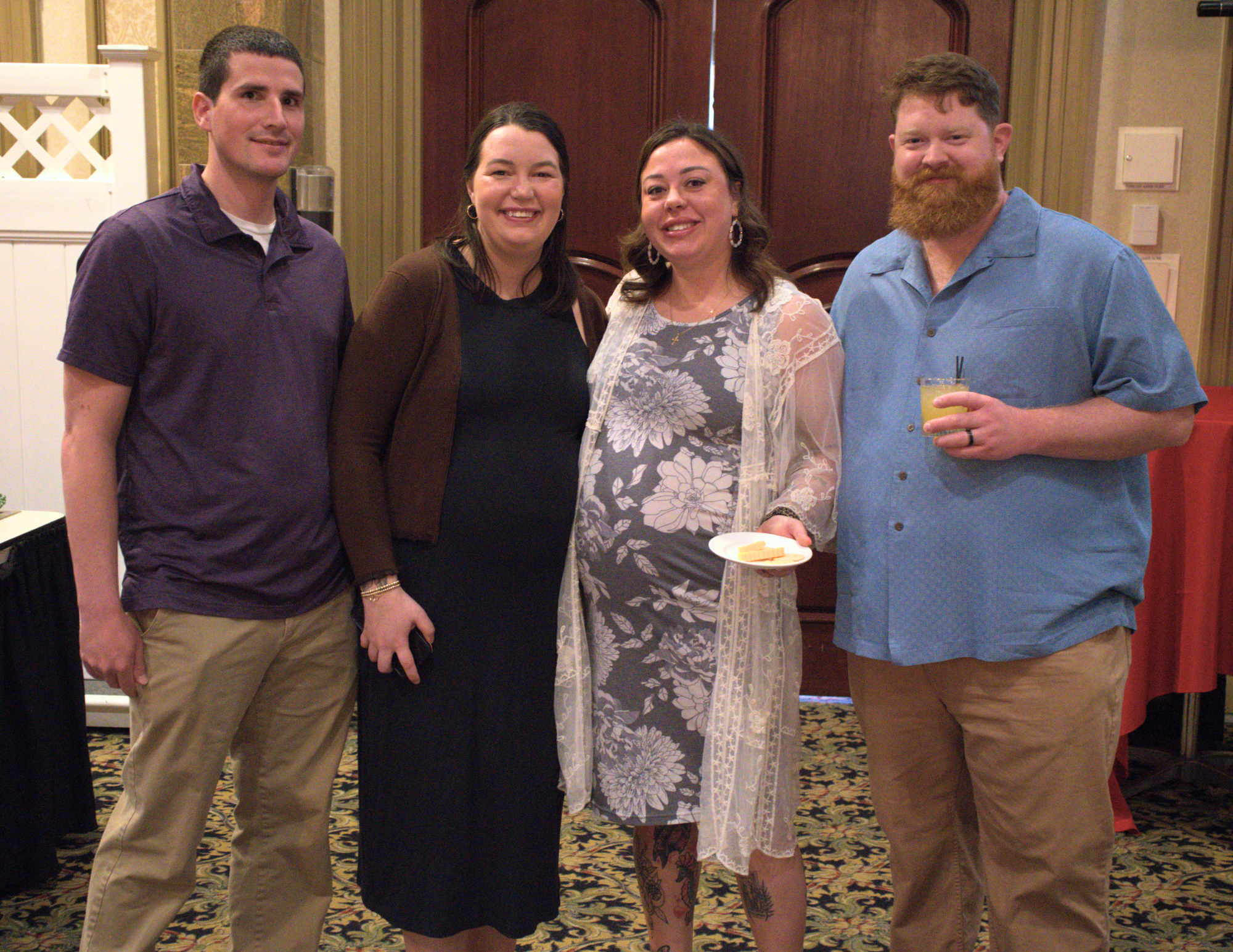 two white couples with two pregnant women smiling at the camera.