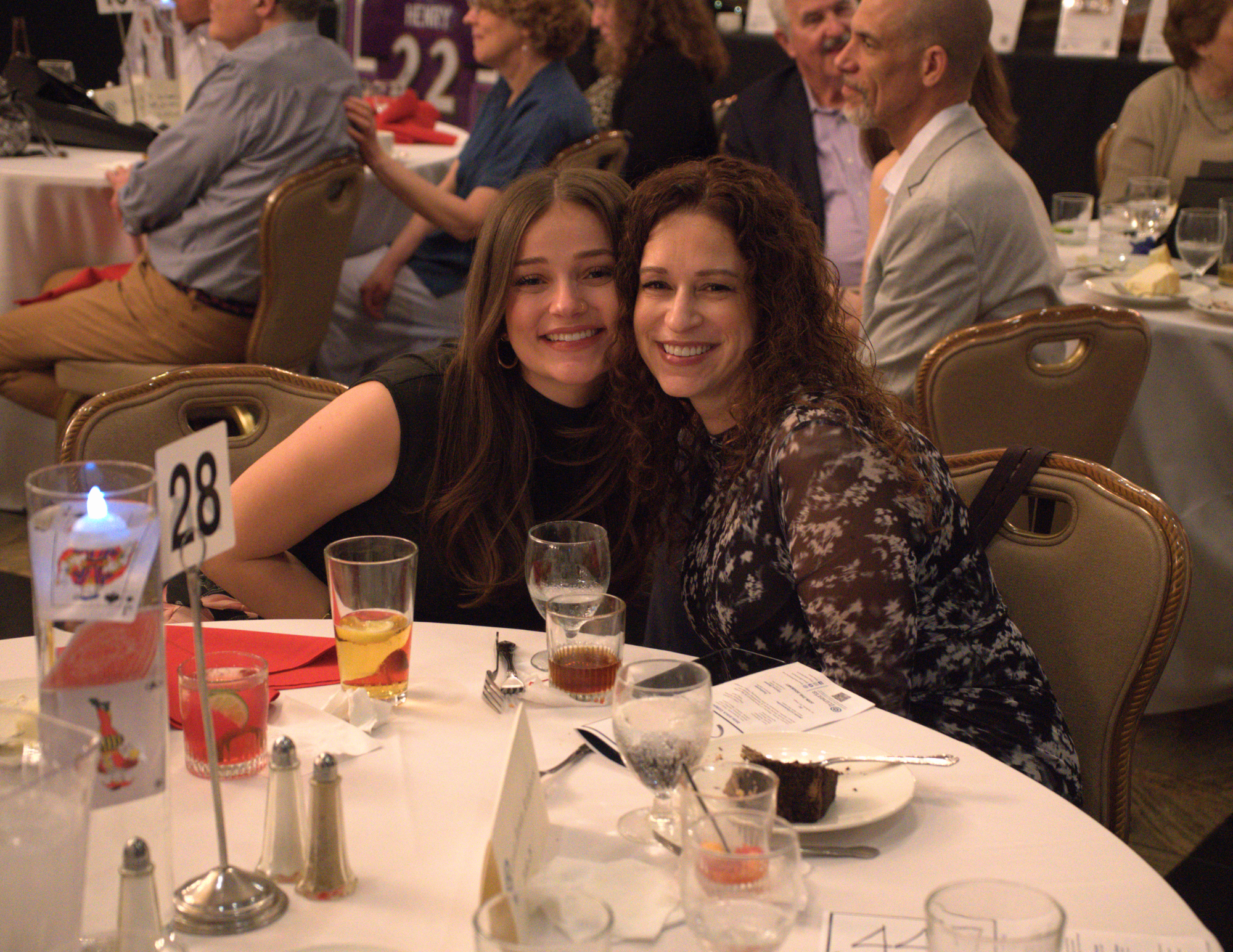 two women smiling sitting down.