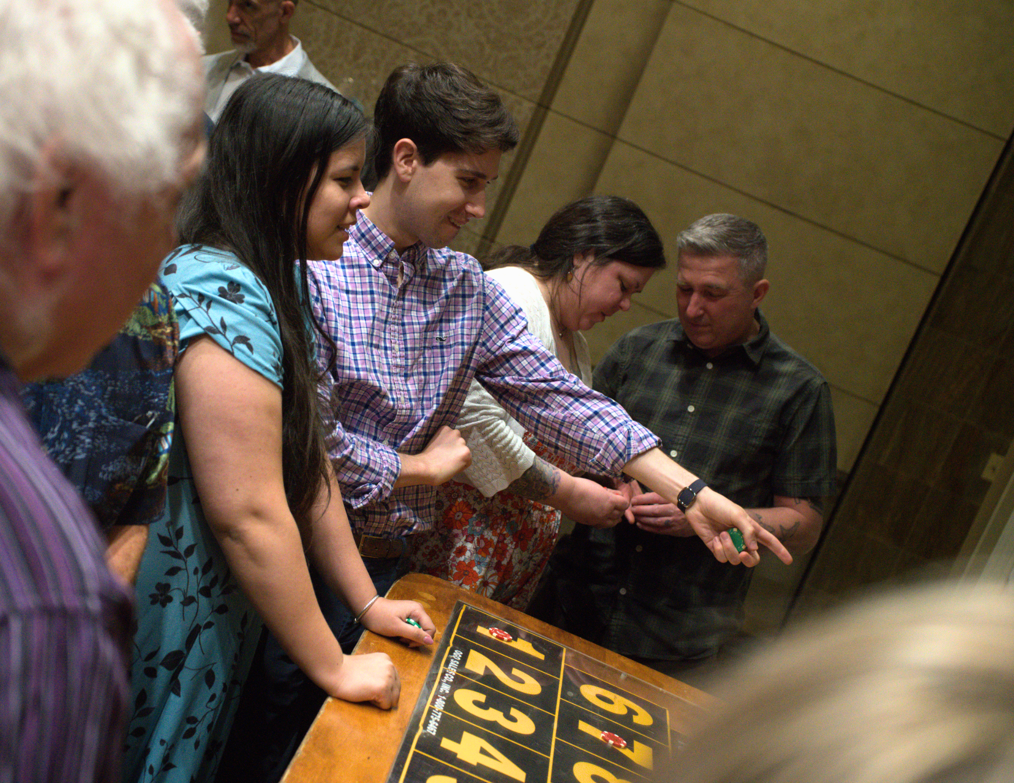 a young couple pointing at the money wheel and smiling.