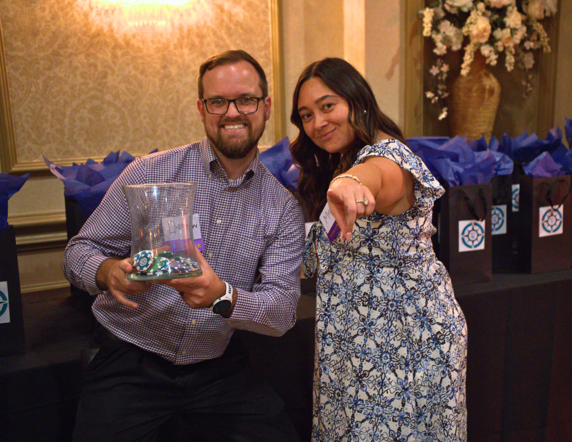 one man and one woman smiling at the camera and holding casino chips.