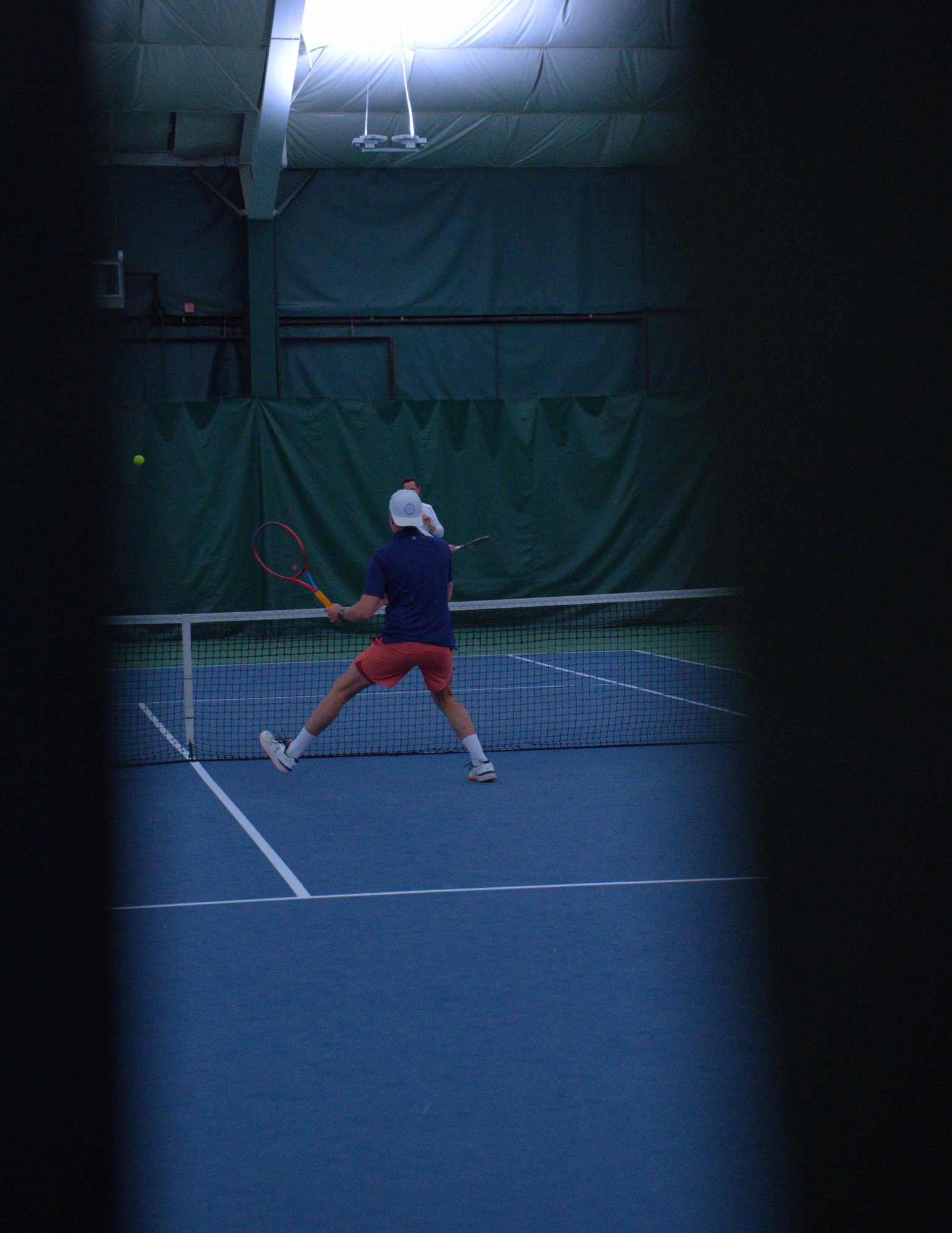 a man in blue hitting a tennis ball across a net.