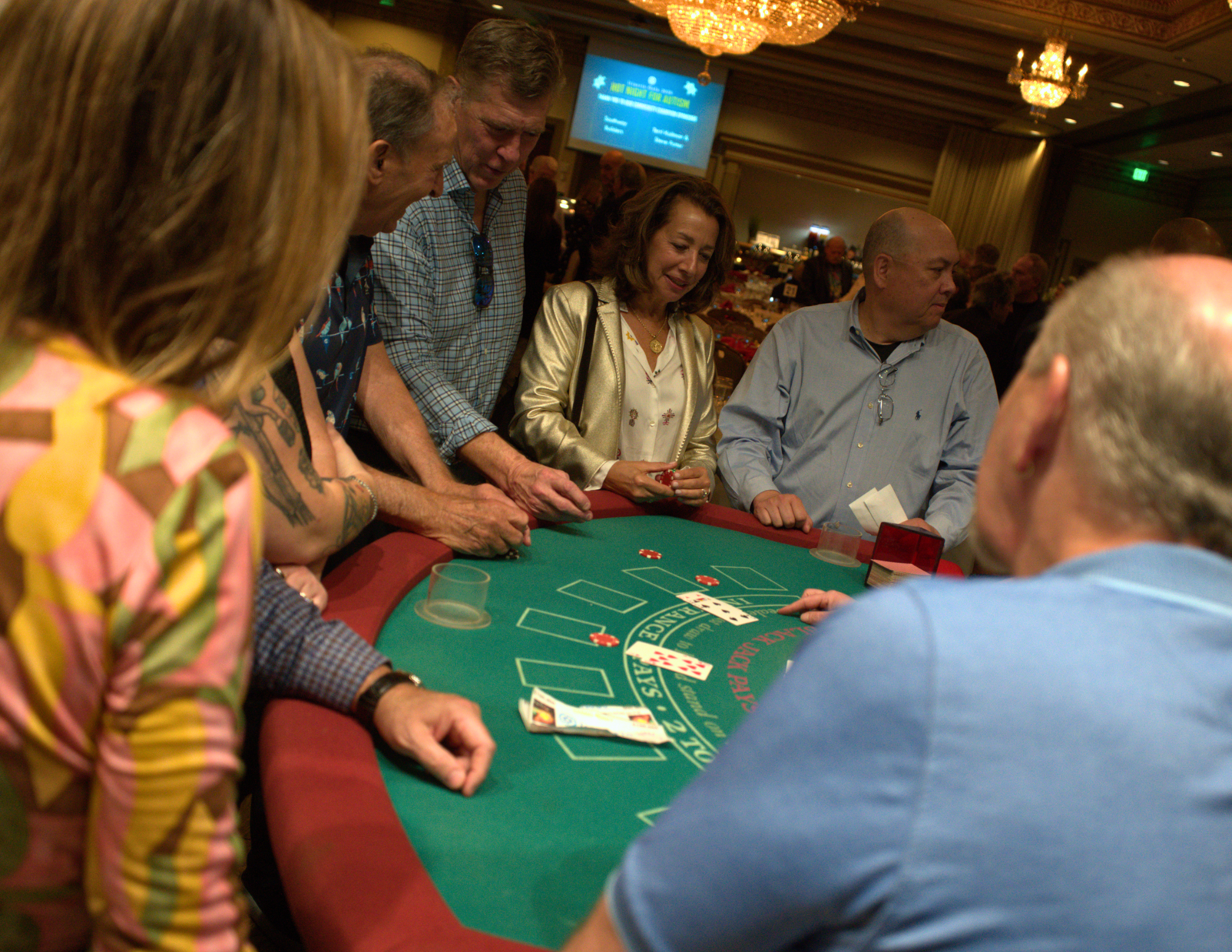 a large group of people smiling and playing blackjack.