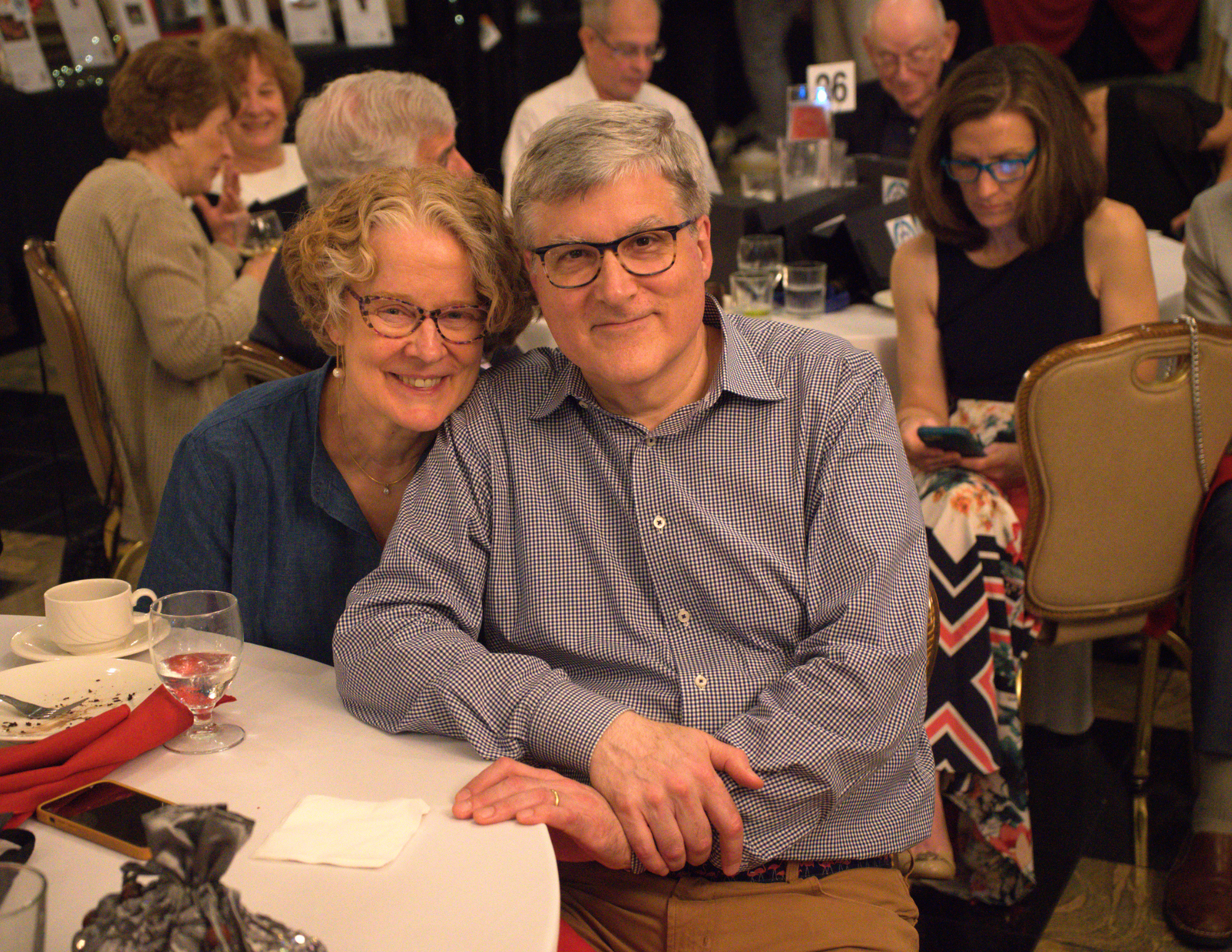 a white older couple sitting together and smiling.