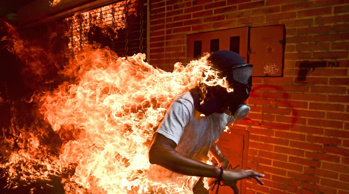 Venezuela Crisis José Víctor Salazar Balza (28) catches fire amid violent clashes with riot police during a protest against President Nicolás Maduro, in Caracas, Venezuela.