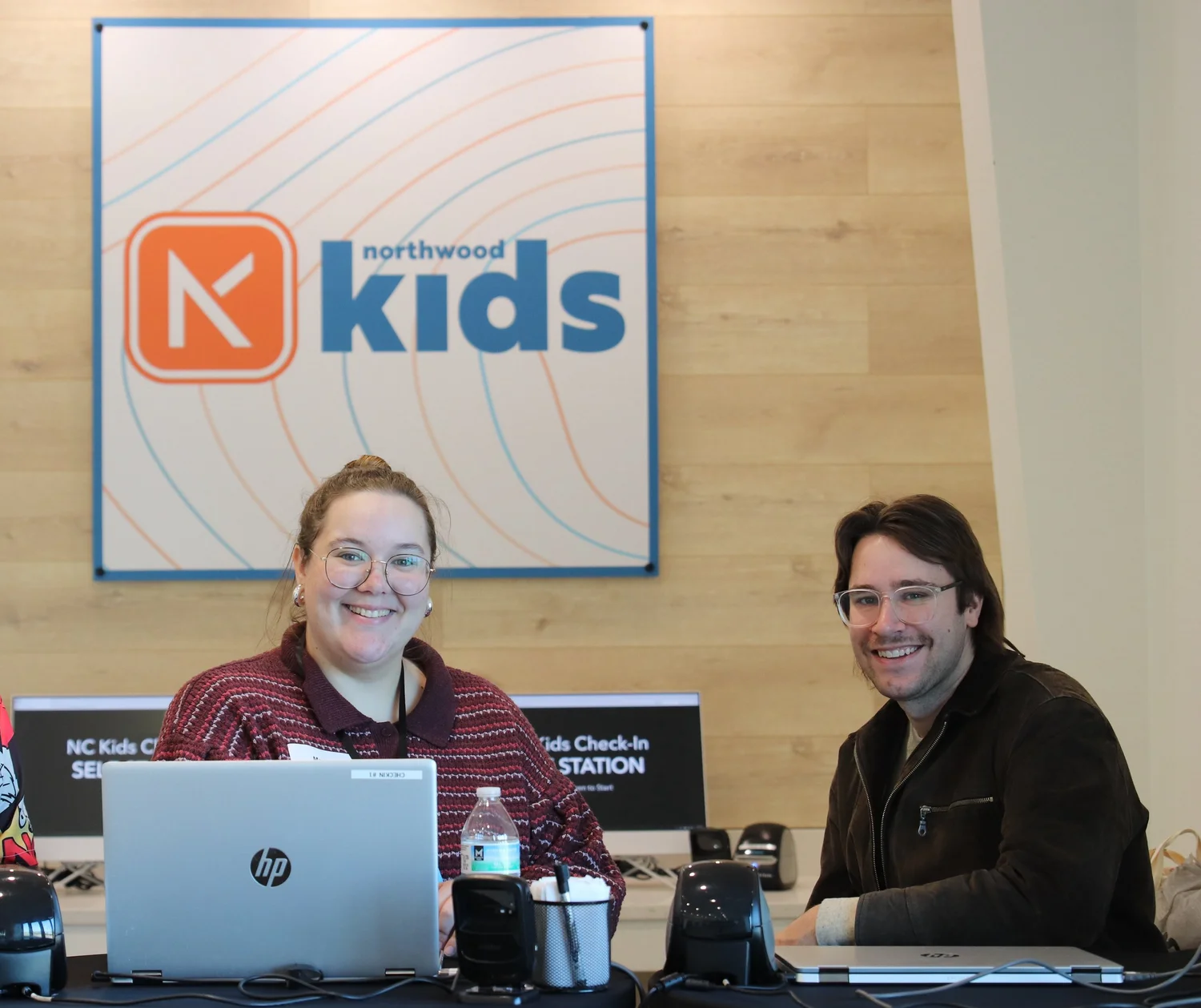 Smiling Northwood Kids team members ready to help families at the check-in desk
