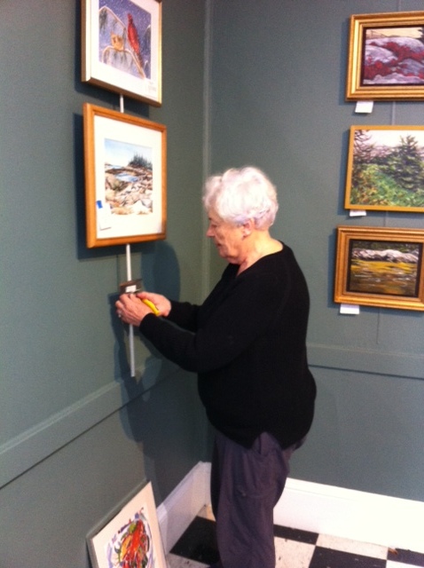 Claudette is busy hanging some of our smaller works.