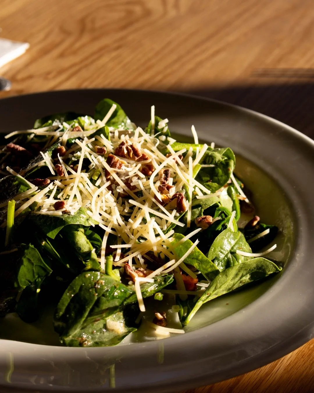 When our summer menu drops, with all its fresh seasonal offerings, our Spinach Salad takes a vacation.

So come and get it one last time before it&rsquo;s gone.

Toasted pecans, grilled red onions, smoked Montana bacon, parmesan, all tossed in that s