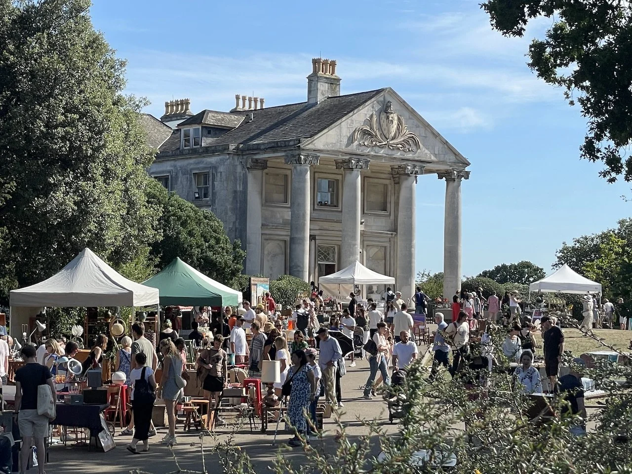 vintage stalls and crowds of visitors in sunshine, at front of the Mansion, Beckenham Place Park in south east London, at So Last Century's Vintage Market at the Mansion