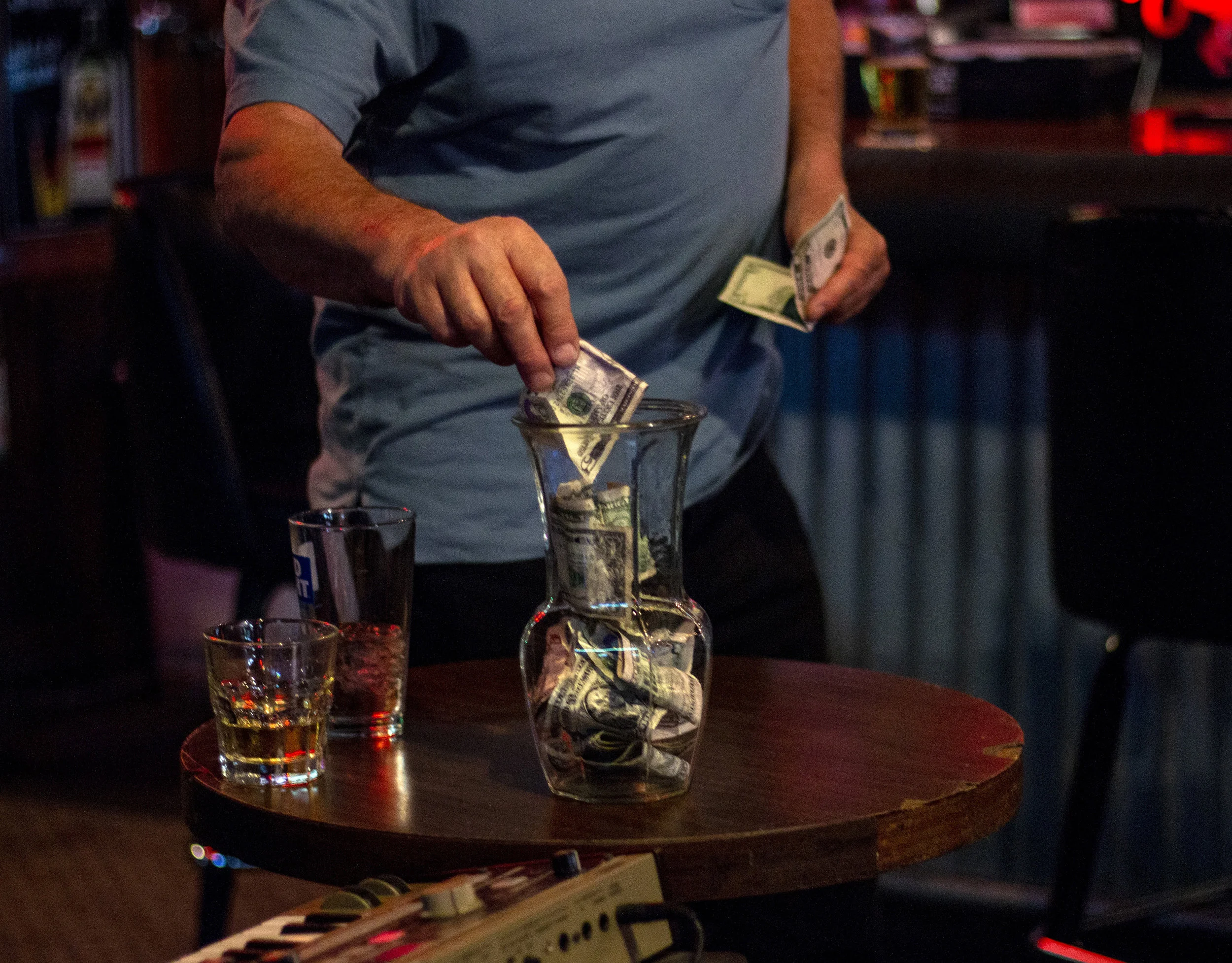 Mulligans customer Steve Chadsev puts money in Ibach’s tip jar. Ibach said of all of the venues in Eugene, he makes the most money playing at Mulligans. “I make 20% of what they sell that night on top of the tips I get.” Ibach said on a good night he can earn around $200 to $300.