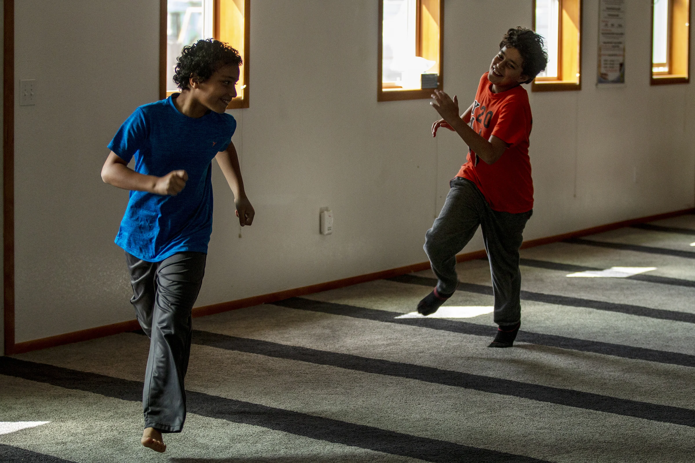  Hasan Eissa, right, and Belal Eissa play tag in the Mosque’s prayer room. After prayer has been completed, children are welcome to play unhindered while they wait for their parents to take them home. 