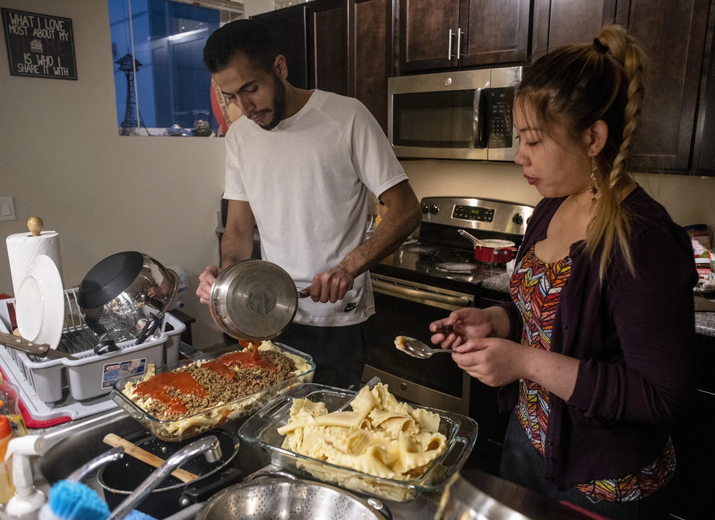  Ebinghannam and Tamimi prepare lasagna for dinner at Ebinghannam’s apartment. Tamimi and Ebinghannam are both students at the University of Oregon. 