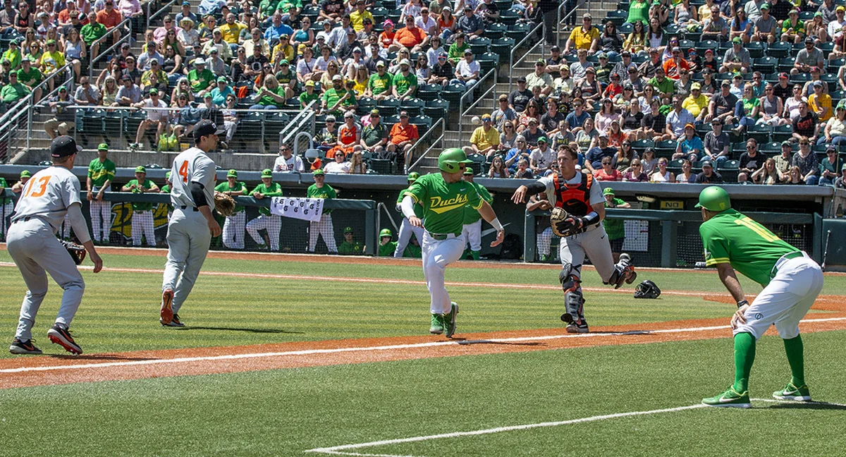  University of Oregon Ducks batter Spencer Steer (#7) runs between Oregon State University Beavers catcher Adley Rutschman (#35) and third baseman George Mendazona (#13). The University of Oregon answered back to yesterday’s loss by defeating Oregon 