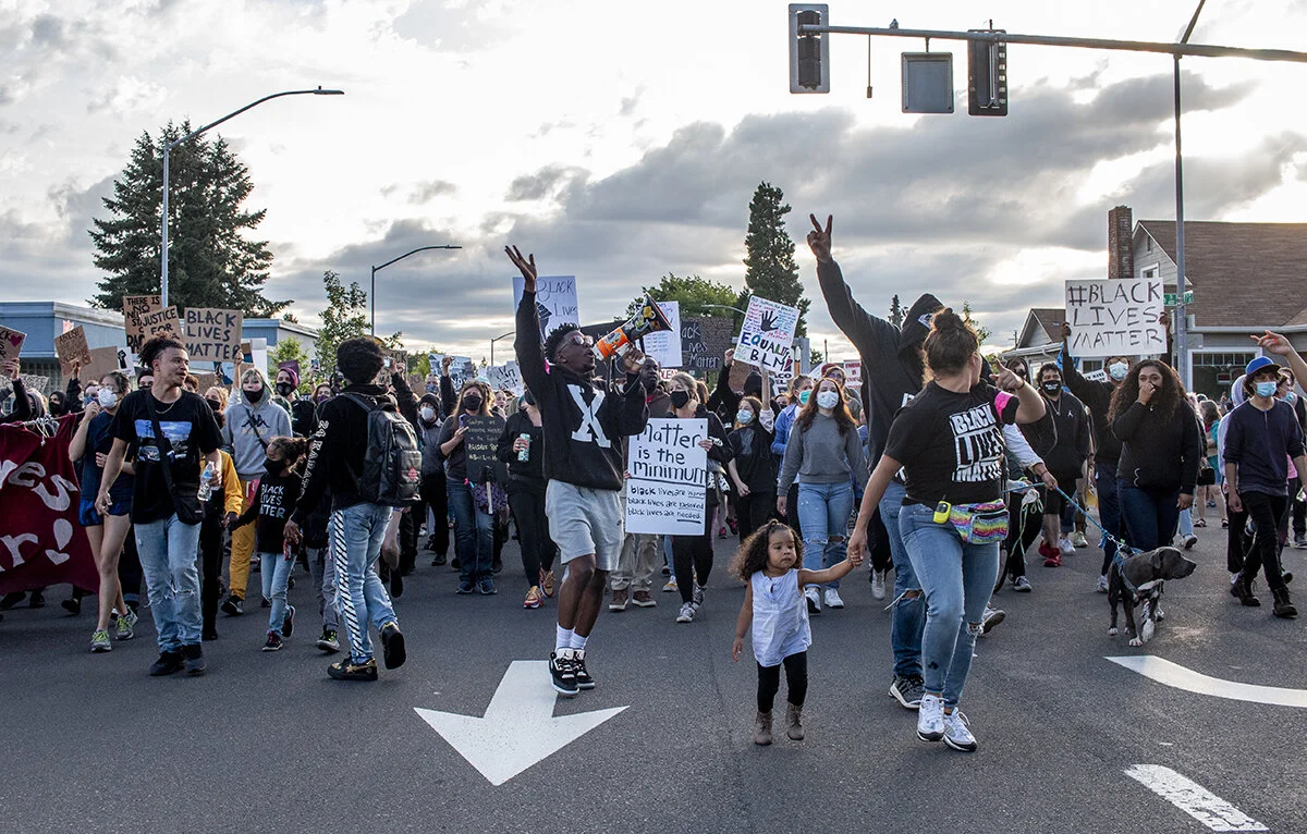  Protestors marching down W 7th Avenue. Hundreds of protestors marched from Monroe Park through the Whiteaker area of Eugene, Oregon, Thursday night June 11. The protest, organized by Black Unity, was dedicated to Trayvon Martin and Tamir Rice. Prote
