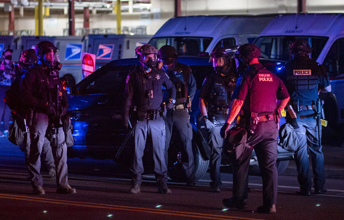 Eugene police officers in riot gear monitor protesters in front of the Lane County jail. Approximately 200 people gathered at the Lane County jail on Wednesday, July 1, to call for the release of recently jailed strikers and to protest conditions th
