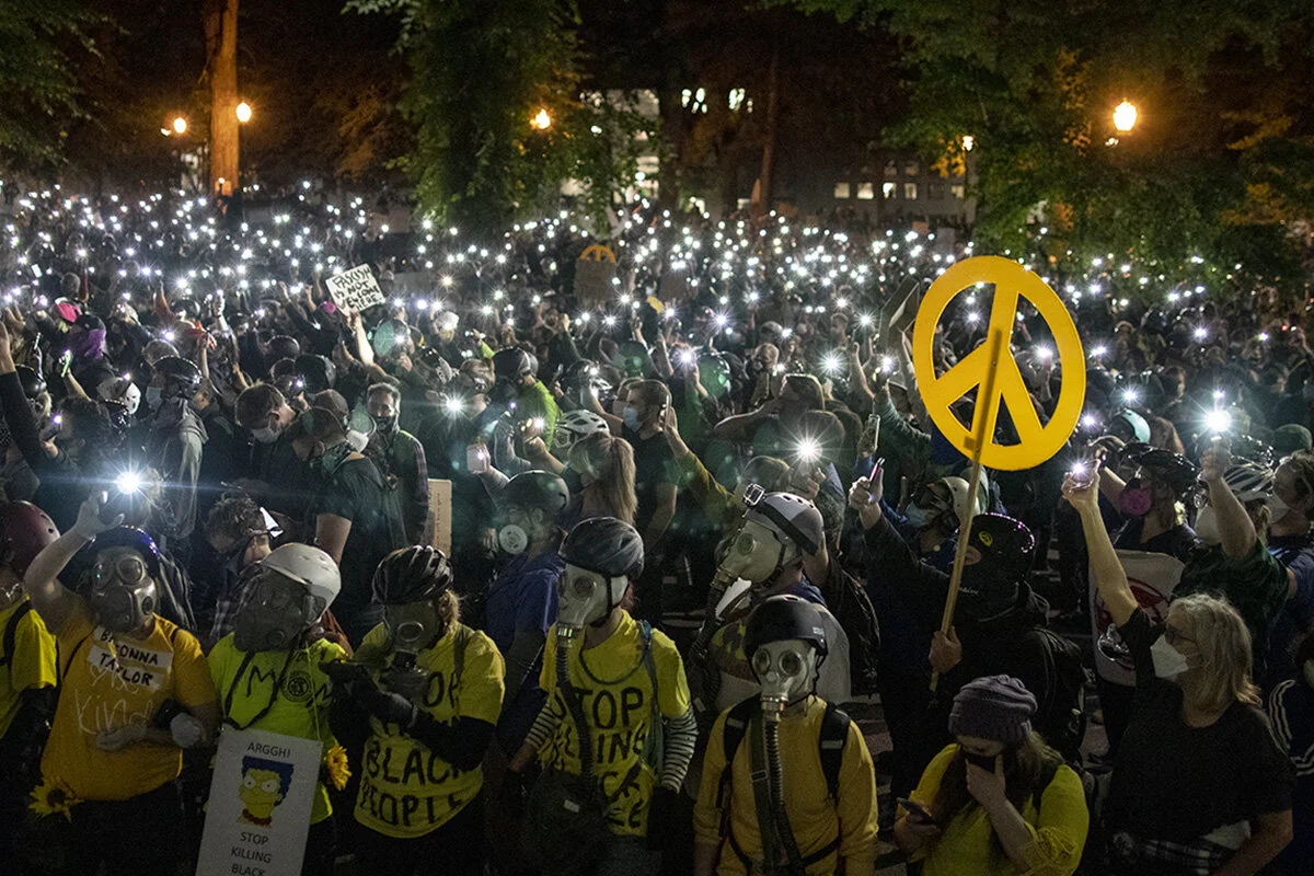  Protesters holding up their smartphone flashlights in front of the Multnomah County Justice Center. More than 3000 people showed up Friday, July 24, for the 58th consecutive night of protests at the federal courthouse and Multnomah County Justice Ce