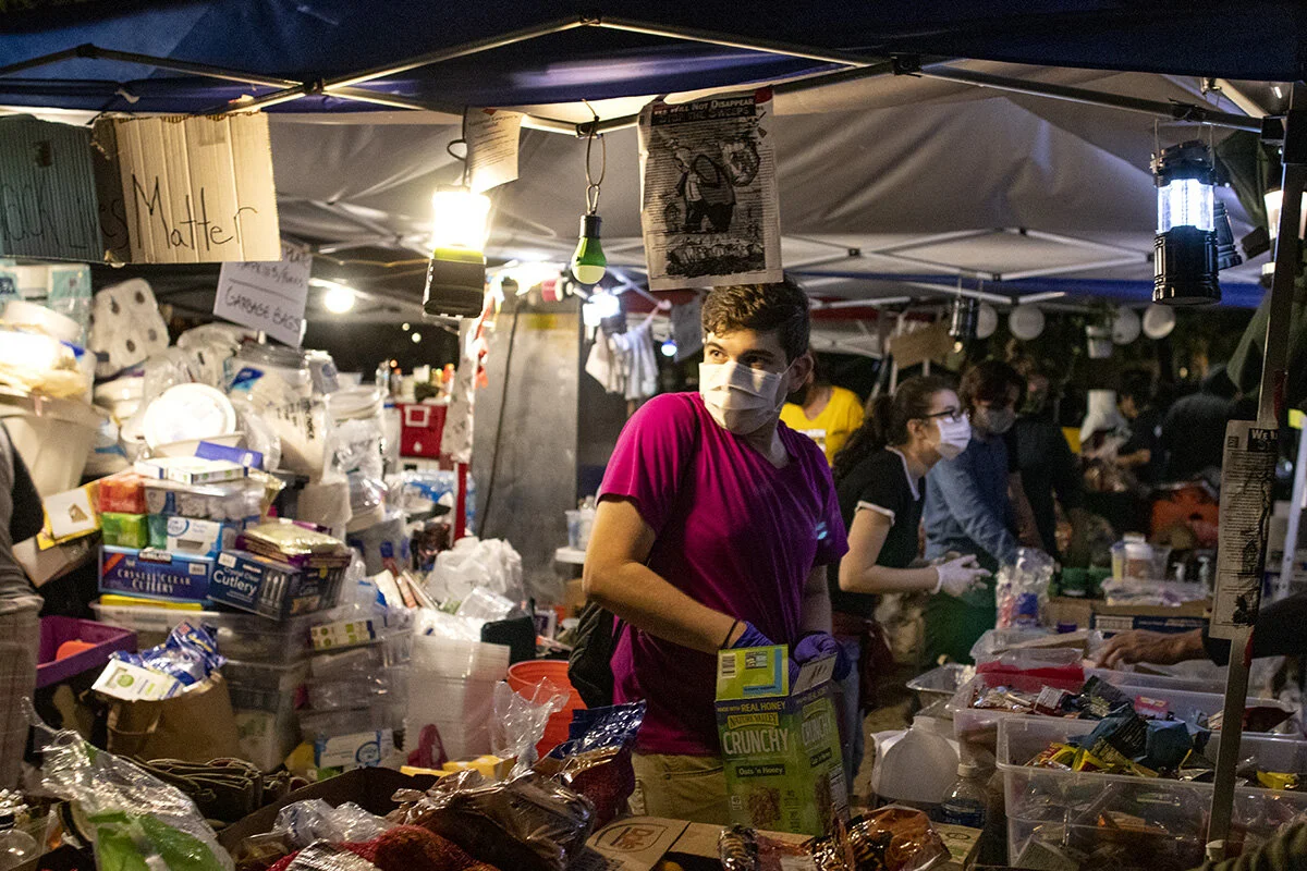  A volunteer running a food stand in Chapman Square offering free food, water and first aid to protesters. More than 3000 people showed up Friday, July 24, for the 58th consecutive night of protests at the federal courthouse and Multnomah County Just