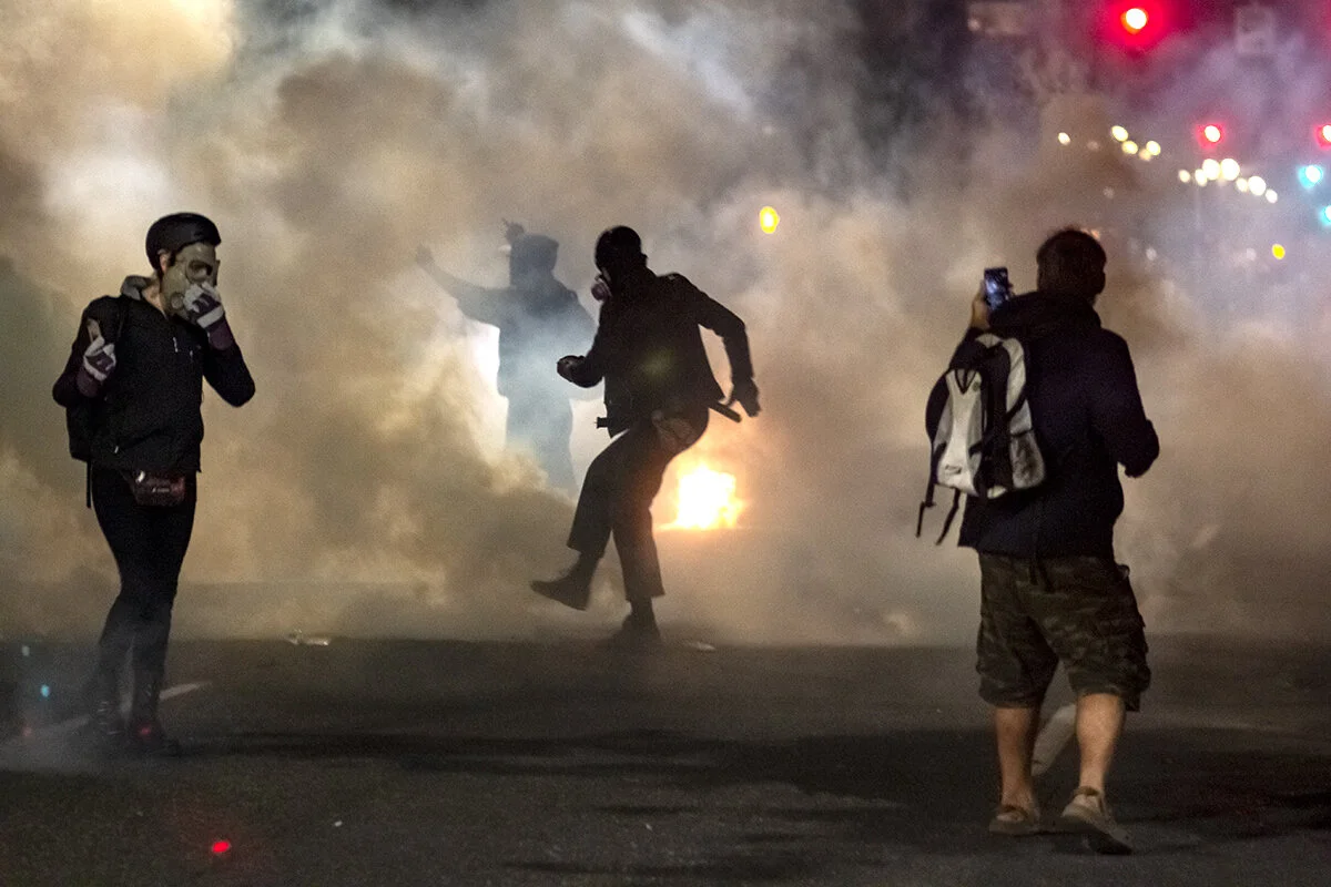  Protesters running through a cloud of tear gas. Police fired pepper balls and roughly 20 cans of tears gas at protesters over the span of three hours on Saturday night, July 11, at the Multnomah County Justice Center in Portland, Oregon. Protesters 