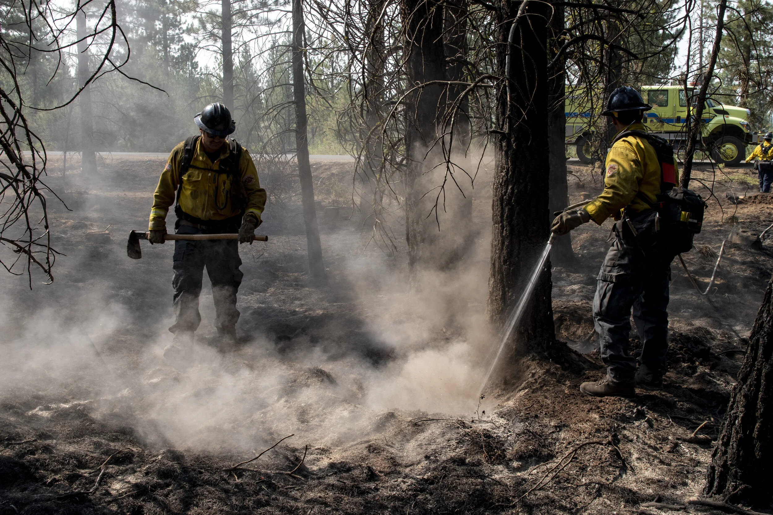  Wildland firefighters mopping up hot spots along the perimeter of the Booteg fire. Mopping up in firefighting is the process of cooling down burnt material left behind by a fire. To ensure the fire is completely out in an area and nothing rekindles,