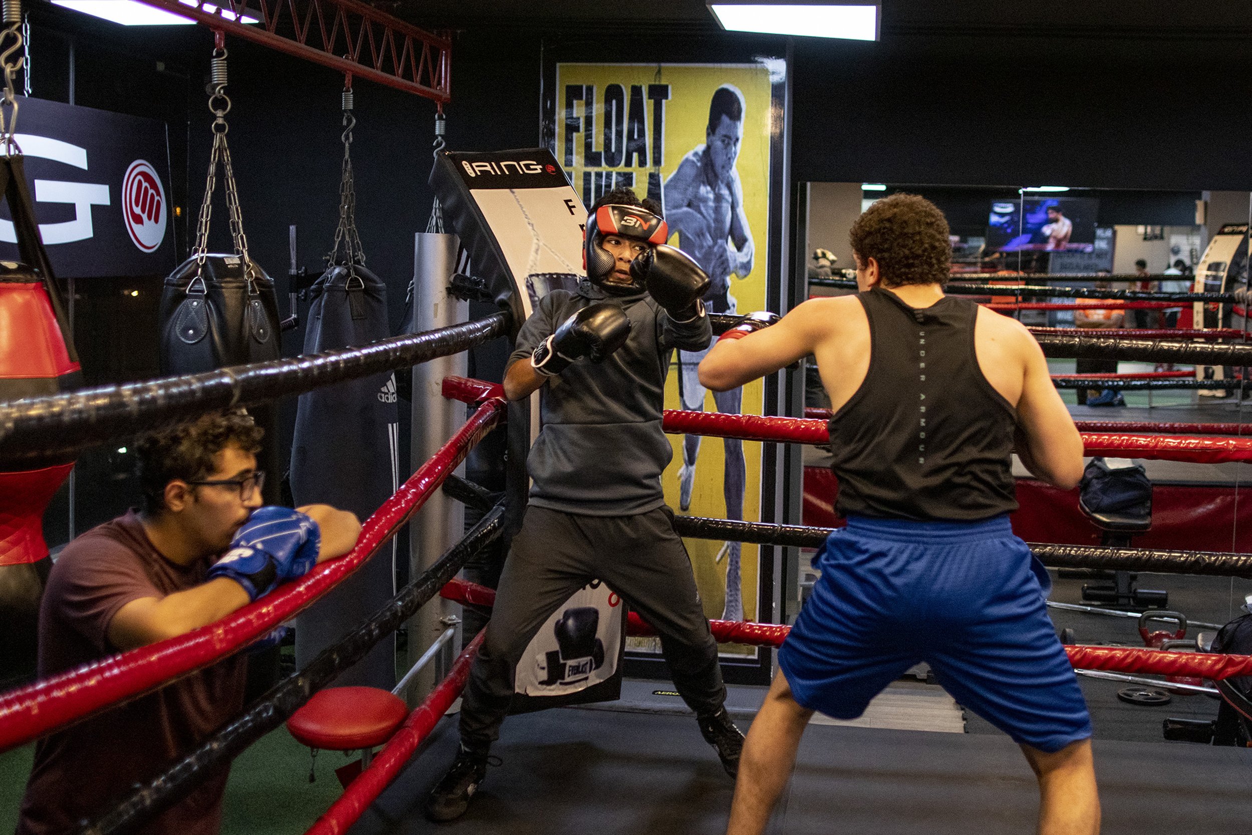 Boxers al-Qaissi, left, and Raad Mesmar, right, sparring at The Ring. Al-Qaissi competes in Jordan's national youth boxing tournament that takes place every year. Behind al-Qaissi a poster hangs depicting Muhammad Ali and his famous quote “float lik