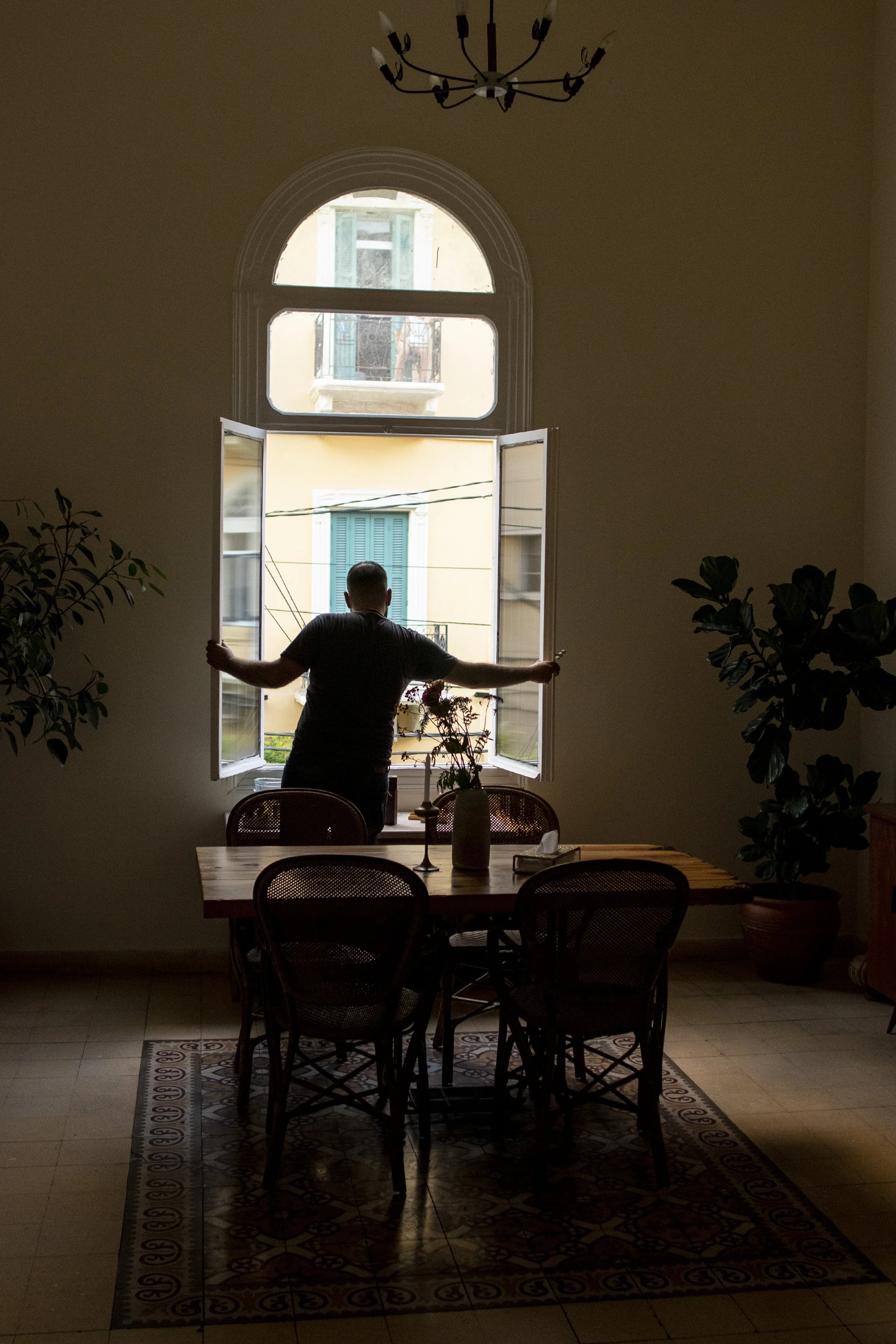  Othman opening a window to let in more light and fresh air during a power outage at the cafe. Algelany said that while the cafe building was not severely damaged by the port blast that took place in Beirut over a year ago on August 4, 2020, the wind
