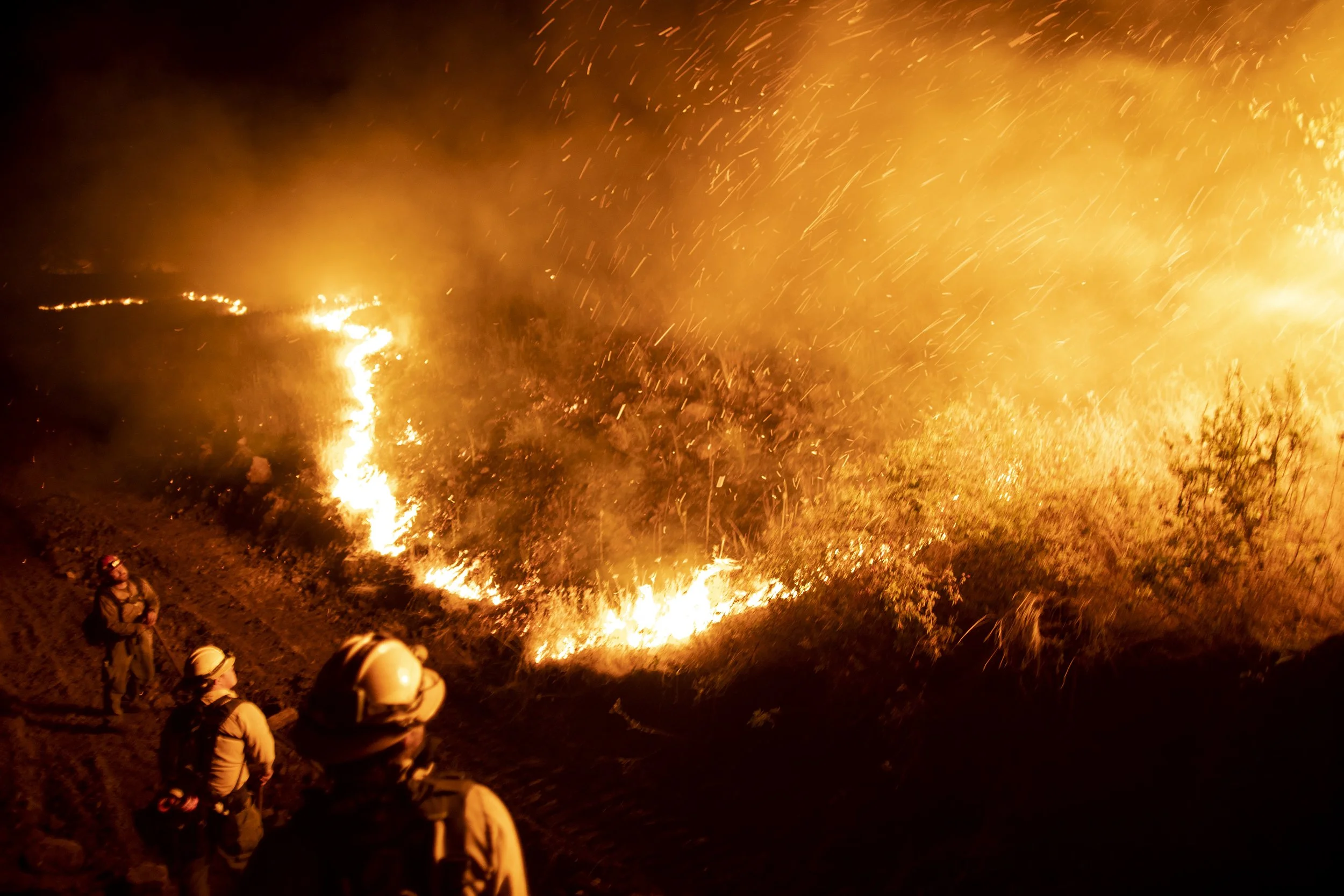  Wildland firefighters monitoring a fire as it approaches a containment line cut by a bulldozer at the Double Creek fire in eastern Oregon. 