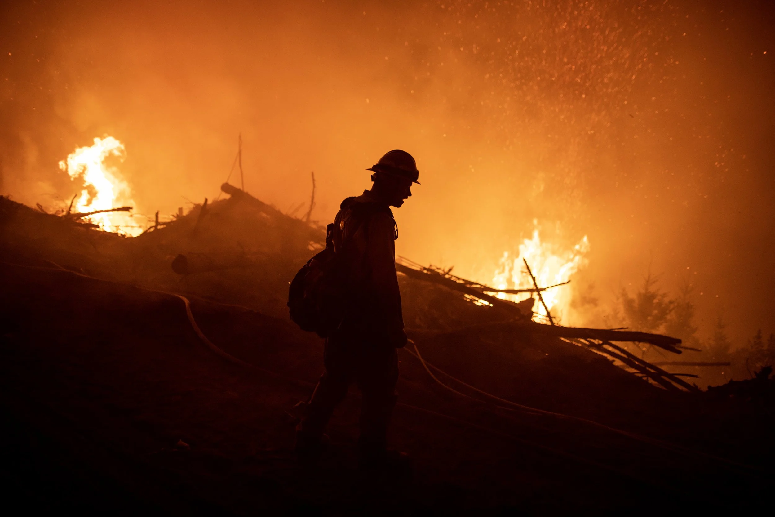  A wildland firefighter working night shift at the Lookout fire in western Oregon walking along a containment line. 