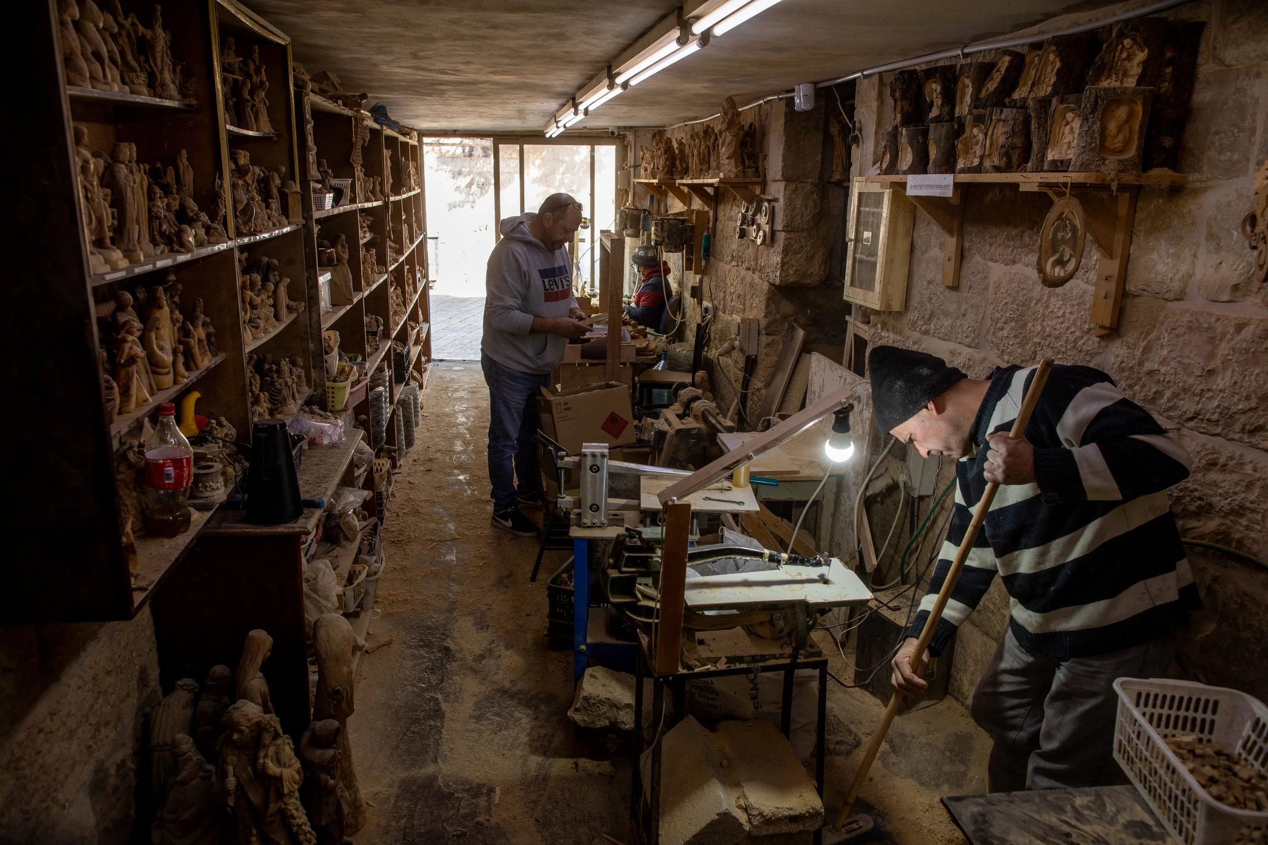  Jack Giacaman (gray sweatshirt) and employees of the My Christmas House souvenir shop in Bethlehem working inside the production area of Giacaman's family-owned store. 
