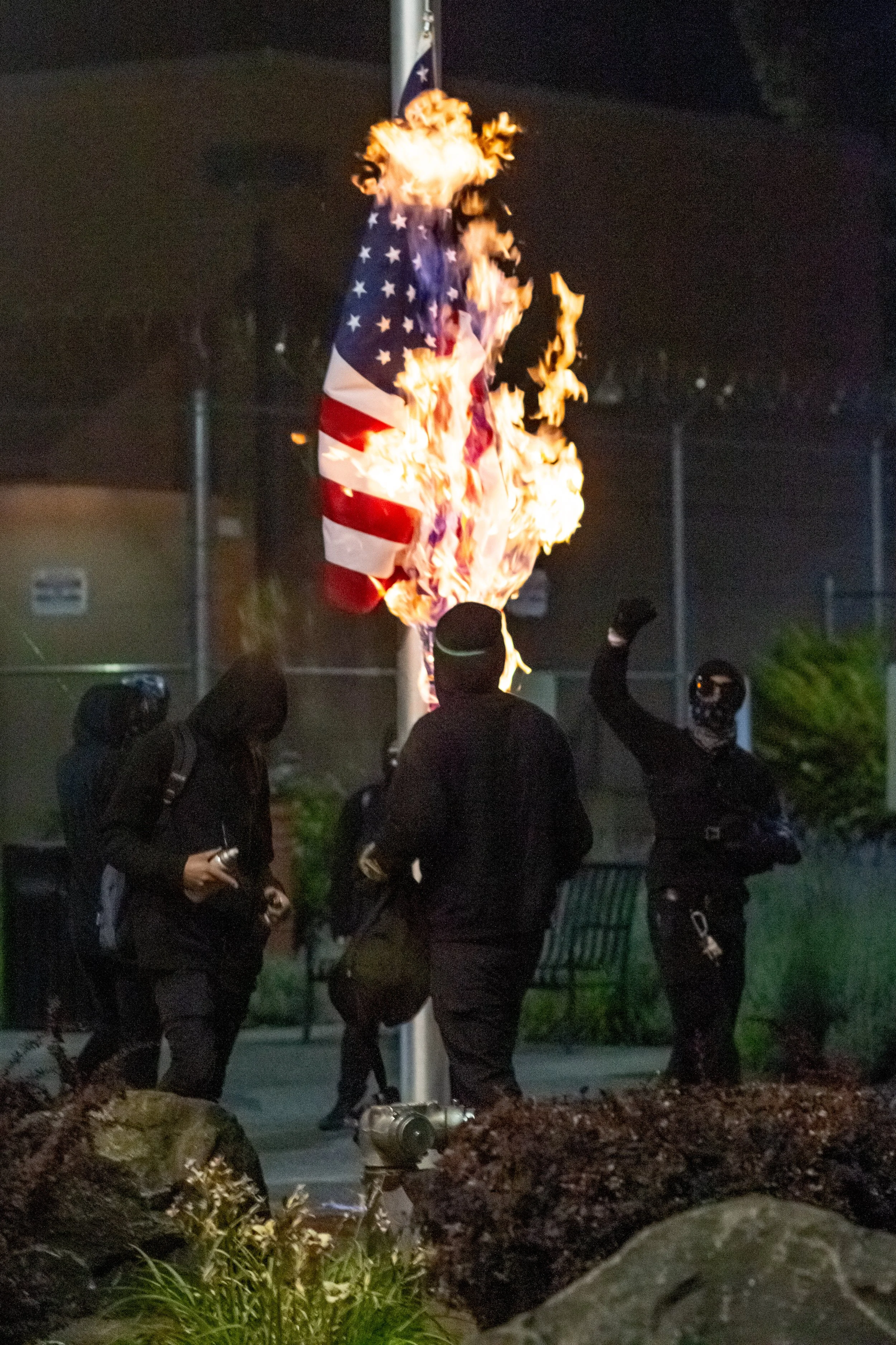  Protesters burn the American flag in front of the Lane County jail in Eugene, Oregon, on July 1, 2020. 