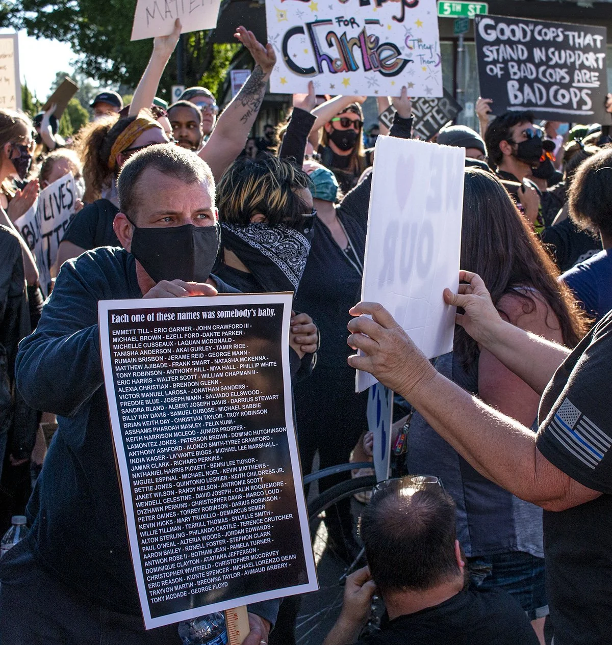  A counter-protester directs their sign at a pro-police rally attendee. 