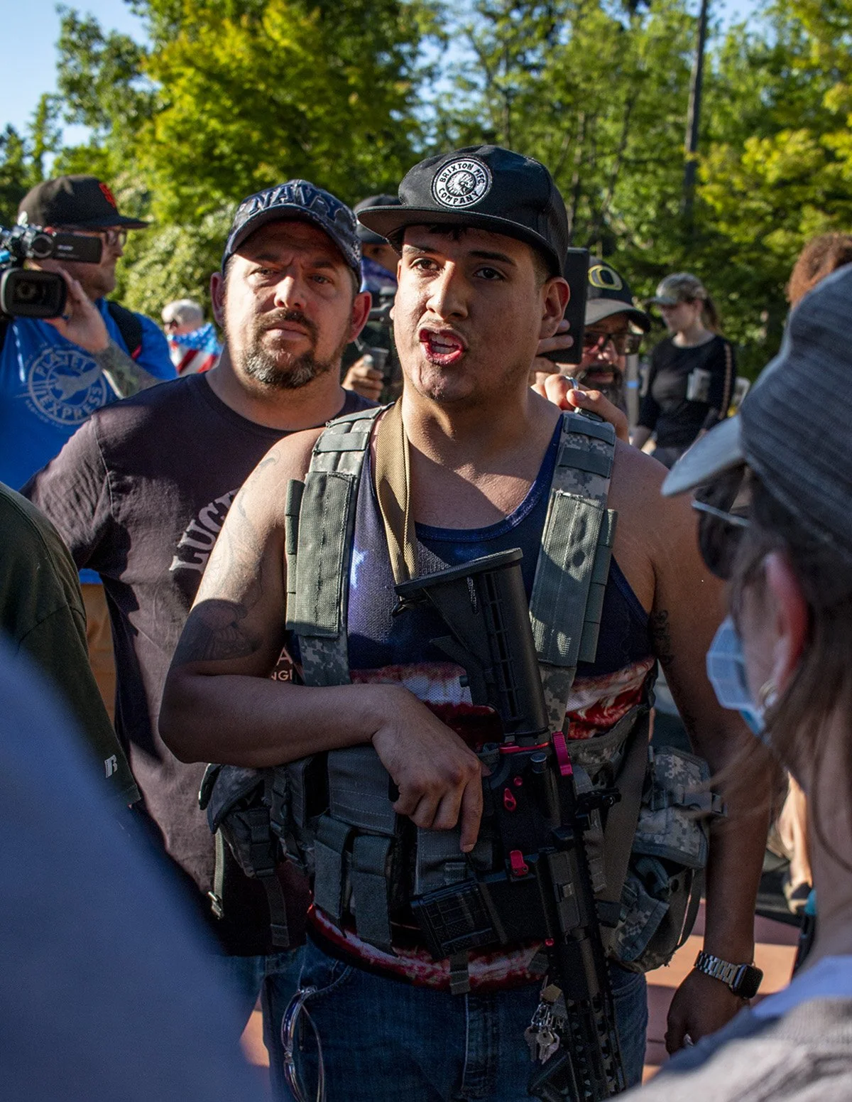  A pro-police rally attendee holds an assault rifle while he shouts at a counter-protester. 