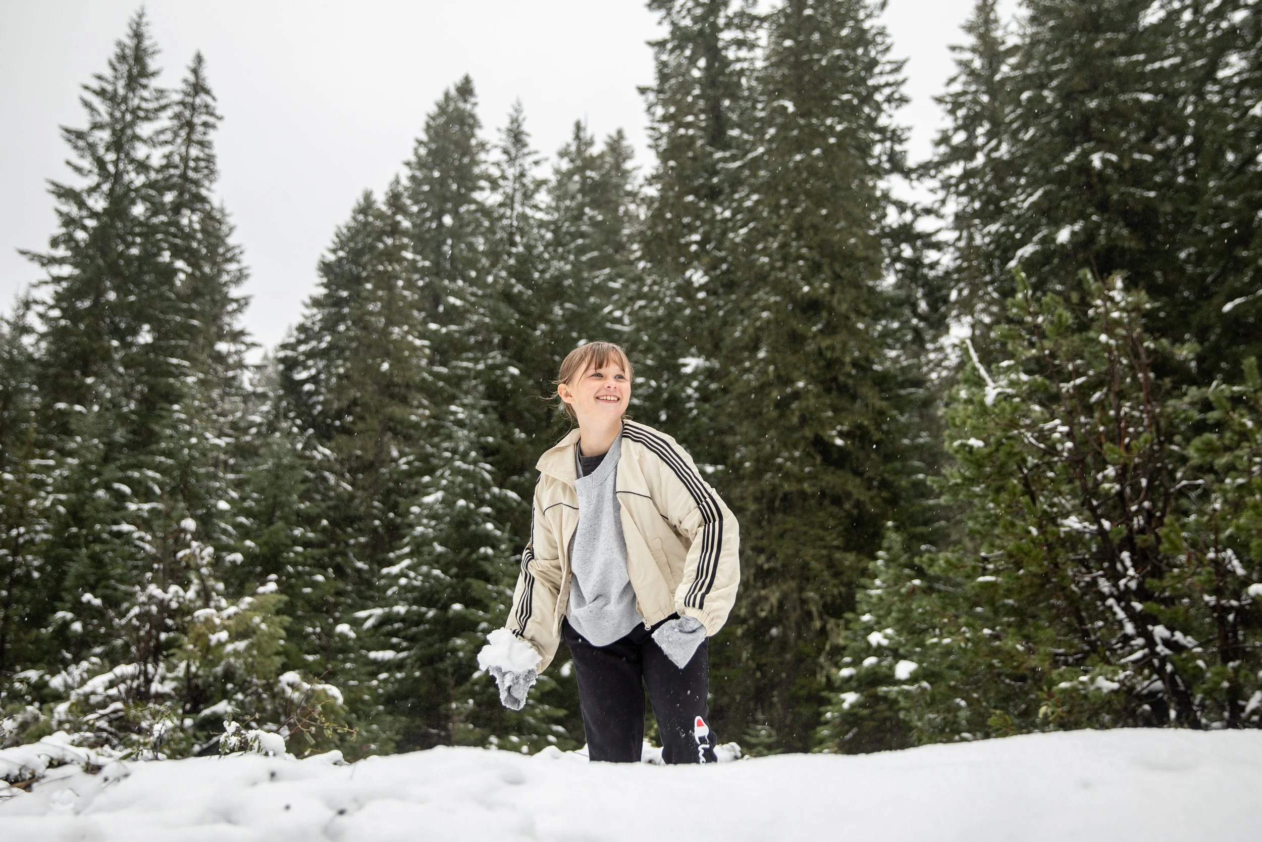  Mia Simpson gets ready to throw a snowball at her dad, Thomas Simpson, after they stopped on the side of the highway to play in the snow during their commute through the Santiam Pass on Oct. 26, 2025. 