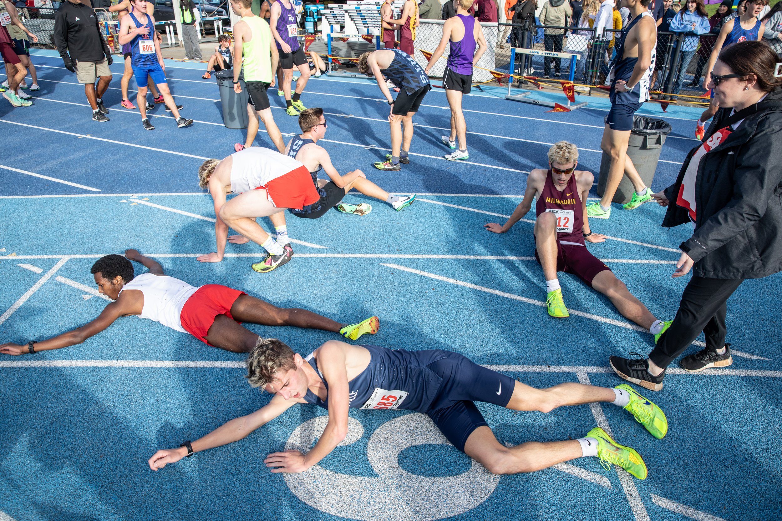  Runners collapse on the ground after crossing the finish line at the OSAA State Cross-Country Championships in Eugene. 