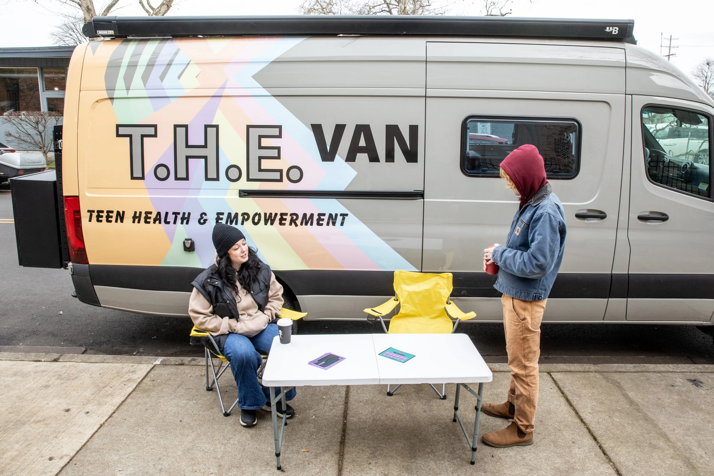  T.H.E. Van counselors Emily Houck, left, and Jeremiah Perry-Weed wait by T.H.E. Van as it is parked outside of Hosea Youth Services in Eugene on Feb. 13, 2026. T.H.E. Van can set up anywhere, but it parks outside of Hosea Youth Services, where unhou