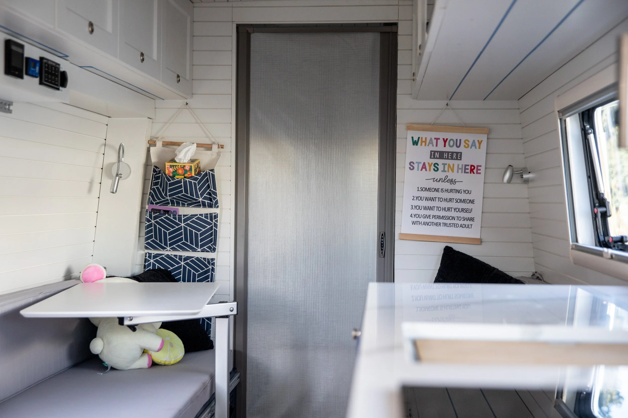  A sign that reads, “What you say in here, stays in here” hangs in T.H.E. Van as it is parked in Eugene, Feb. 4, 2026. The interior of T.H.E. Van is designed to resemble the inside of a therapist’s office. 
