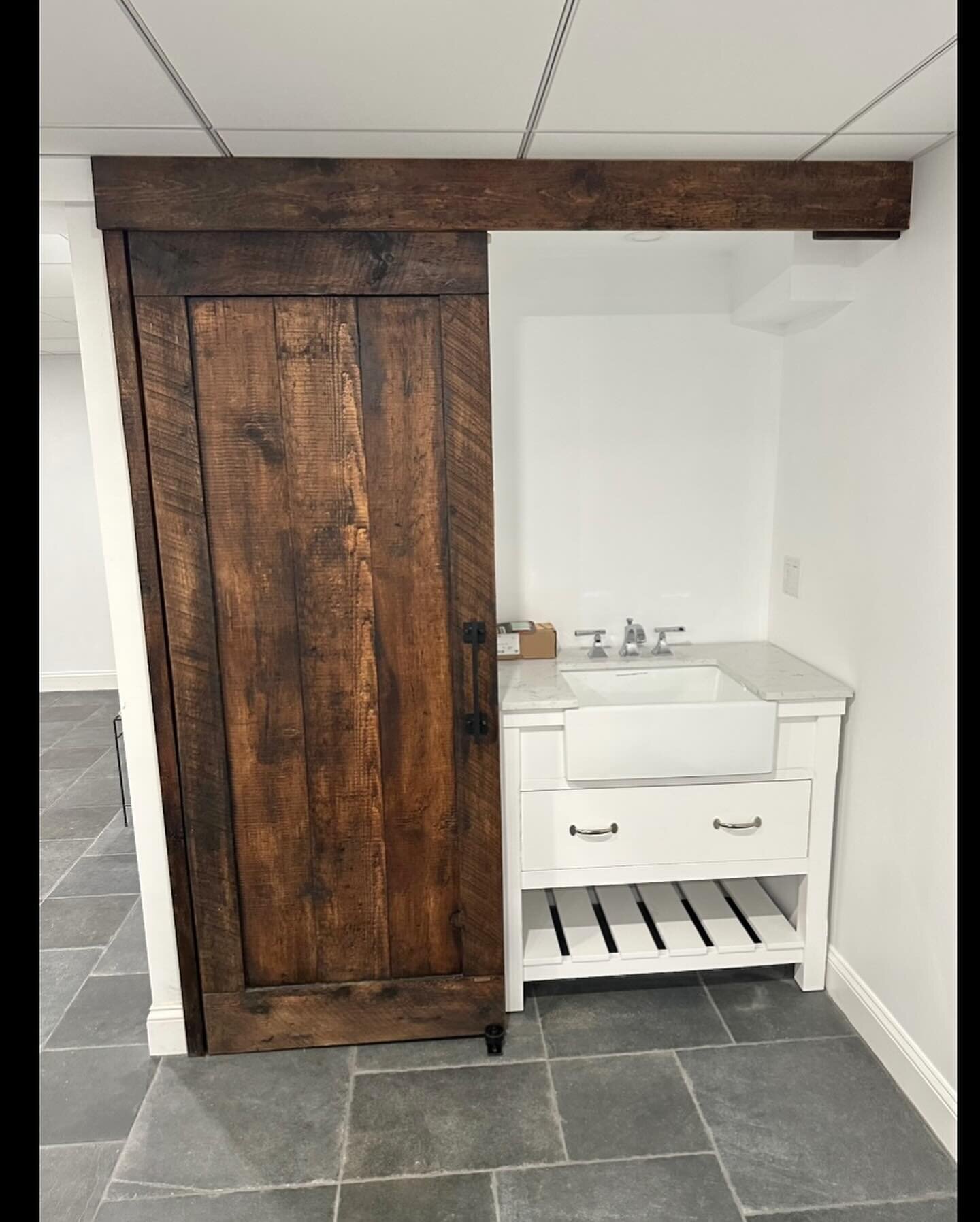 Pete and Deana from Beverly hired a local builder/craftsman to install a hidden track for this rustic brown barn door slab made by The Barndoorist to be 1-3/4&rdquo; thick. 

The door would cover the newly finished basement laundry alcove when closed