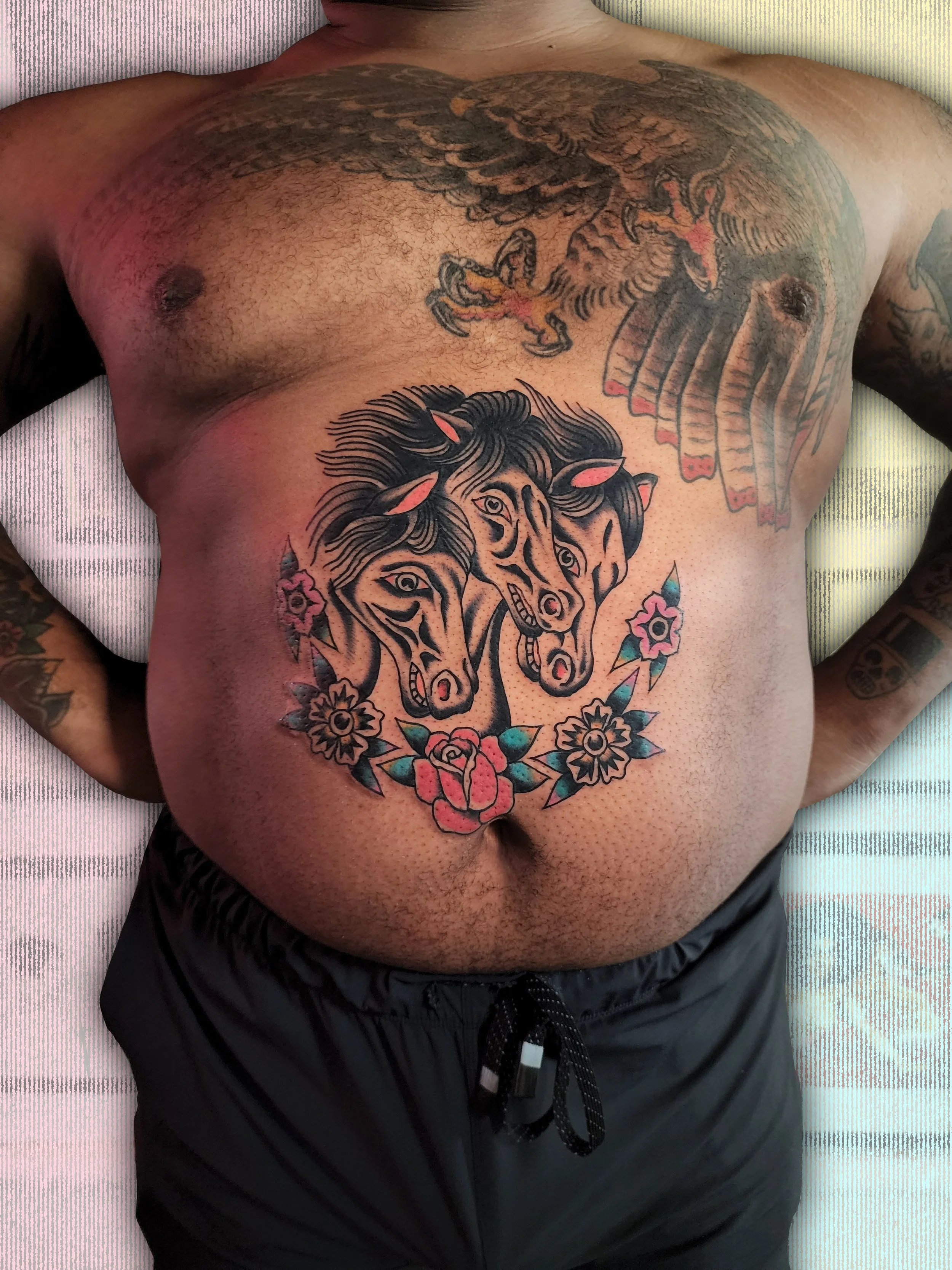  Tattoo of Pharaoh's Horses (3 horse heads) with floral accents below in bright colors, located on stomach.  