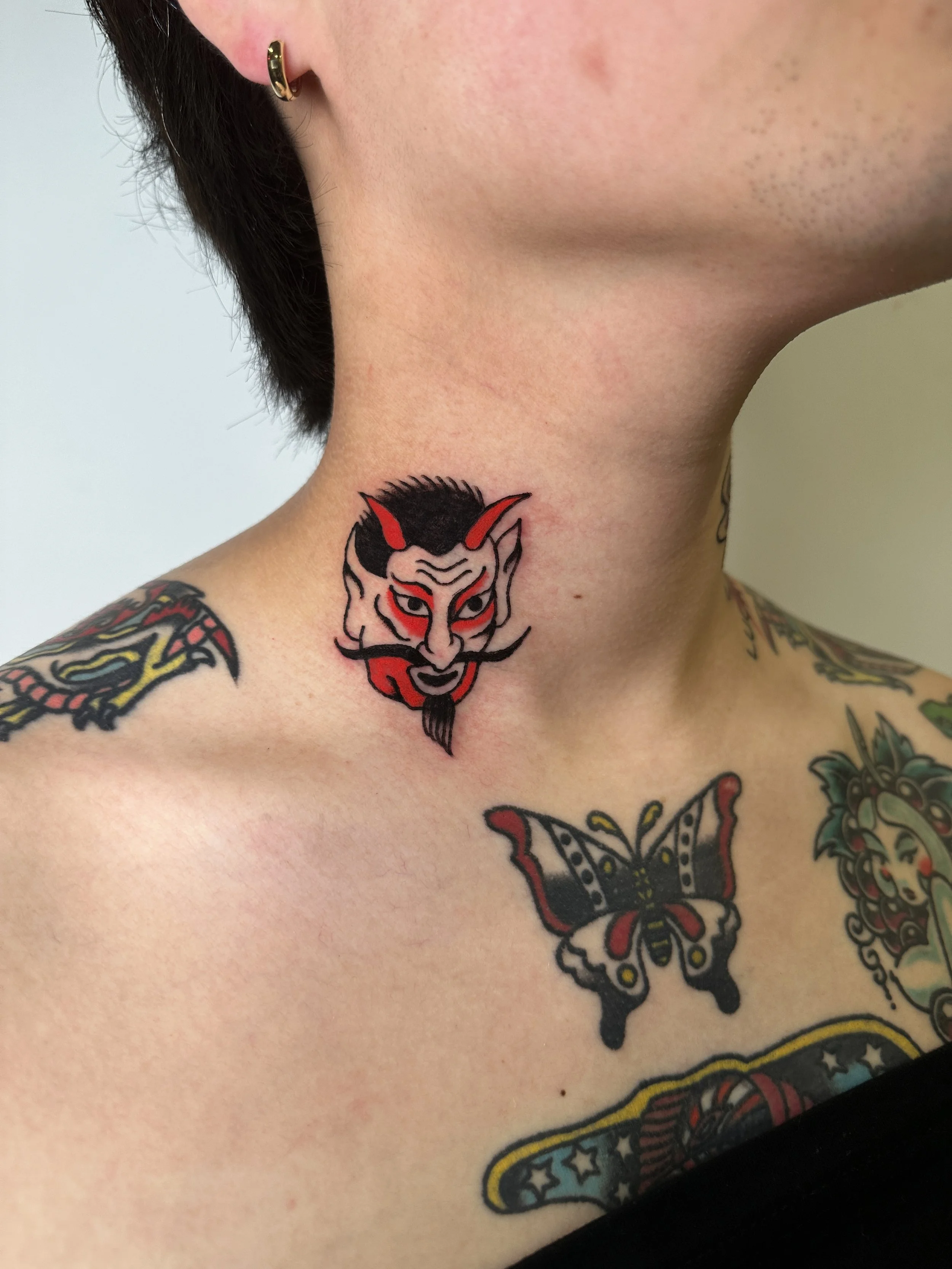  Devil head tattoo on lower side of neck.  